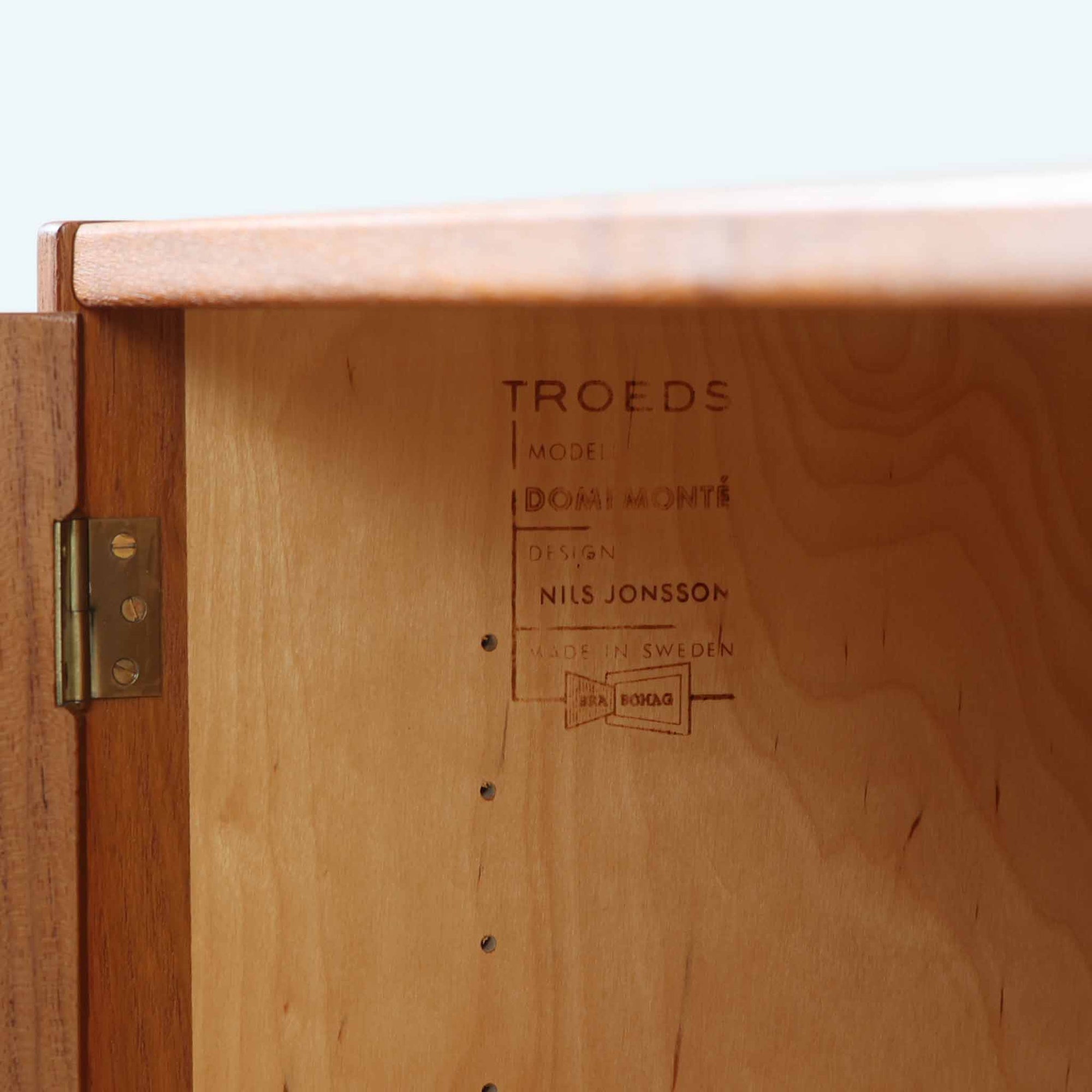 Nils JonssonがTroeds社のためにデザインした「Domi Monté」モデルのディスプレイシェルフ。チーク材を贅沢に使用し、温かみのある木肌と洗練されたフォルムが魅力の一台です。上部には高さ調整が可能な可動棚が8枚備わり、本やオブジェのディスプレイに柔軟に対応。下部には扉付き収納と仕切り付きの引き出しが配されており、実用性にも優れます。背面にはTroeds社の刻印が残されており、スウェーデン製ビンテージ家具としての確かな出自を物語ります。空間に落ち着きと上質な雰囲気を添える、北欧モダンらしい逸品です。