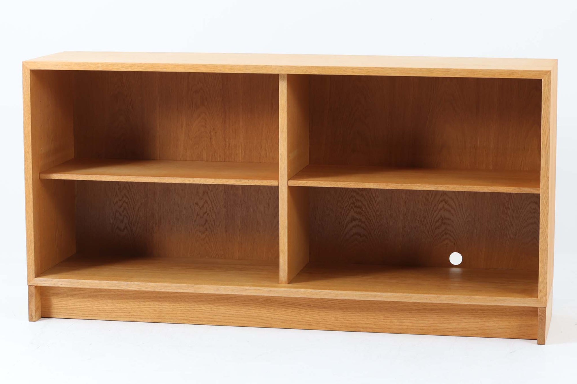 デンマークを代表するデザイナー、Børge mogensen（ボーエ・モーエンセン）によってデザインされた、Karl Andersson（カール・アンダーソン）社製のスモールブックシェルフです。素材には、美しい木目と優れた耐久性を兼ね備えたオーク材を使用しており、ナチュラルで温かみのある佇まいが魅力です。幅134cmと程よいサイズ感で、リビングや書斎、子ども部屋など、さまざまな空間に取り入れやすい仕様となっています。シンプルな構造の中に、モーエンセンらしい実用性と機能美が凝縮されており、背面には配線用の穴も設けられているため、テレビ台やAVボードとしての使用も可能です。実際に前オーナーもAVボードとして使用していた形跡があり、汎用性の高さも魅力のひとつ。北欧デザインの真髄を感じられる、実用性と美しさを兼ね備えた一台です。