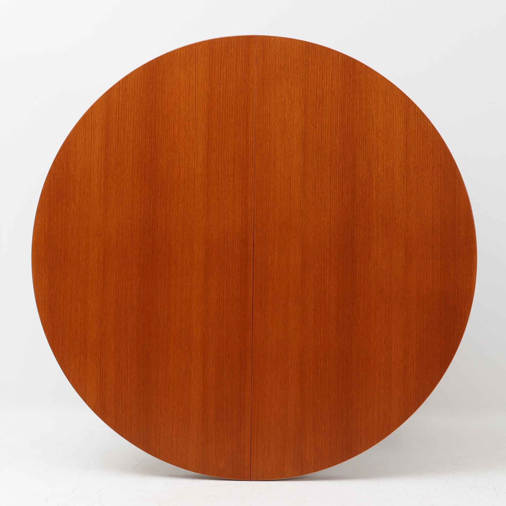 チーク材の天板とオーク材の脚部が美しく調和したこちらの円形エクステンションダイニングテーブルは、デンマーク製ならではの丁寧な仕上げと実用性が魅力の北欧ビンテージ家具です。直径110cmの円形天板は、中央に拡張板を2枚追加することで広々としたオーバル型に変化し、来客時やホームパーティーなどにも柔軟に対応できます。細身のテーパー脚が軽やかな印象を与え、温かみのある木の表情が空間に自然と溶け込む逸品です。