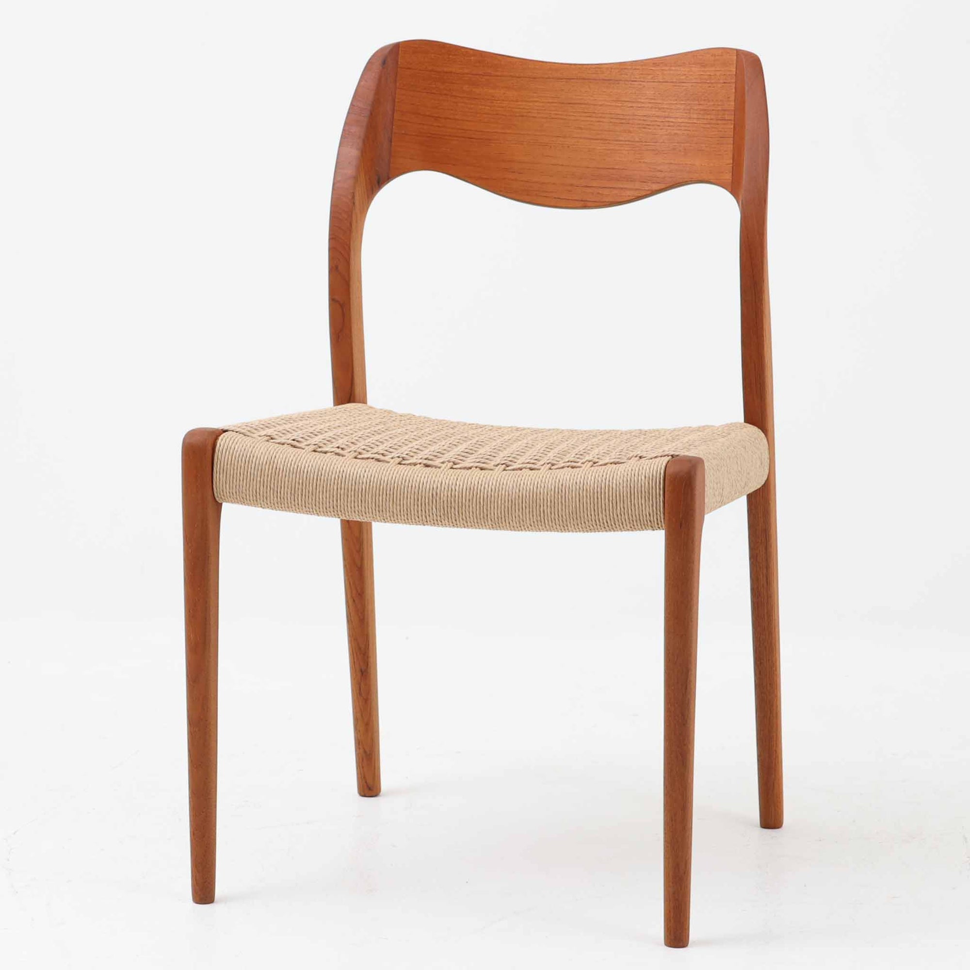 Niels Otto Mollerが手掛け、J.L. Mollers Mobelfabrik社によって製造されたModel 71は、チーク材とペーパーコードの美しい組み合わせが魅力の北欧ビンテージダイニングチェアです。背もたれから後脚へと流れるように繋がる柔らかな曲線が、身体を包み込むような快適な座り心地を生み出し、見た目にも優雅な印象を与えます。座面には職人の手作業によるペーパーコードが丁寧に張られ、自然素材ならではの温もりと耐久性を兼ね備えています。シンプルで洗練された佇まいは、ダイニングだけでなく書斎や玄関にも馴染みやすく、暮らしの中で長くご愛用いただける一脚です。ビンテージ品でのみ入手可能なチーク材のモデルです。