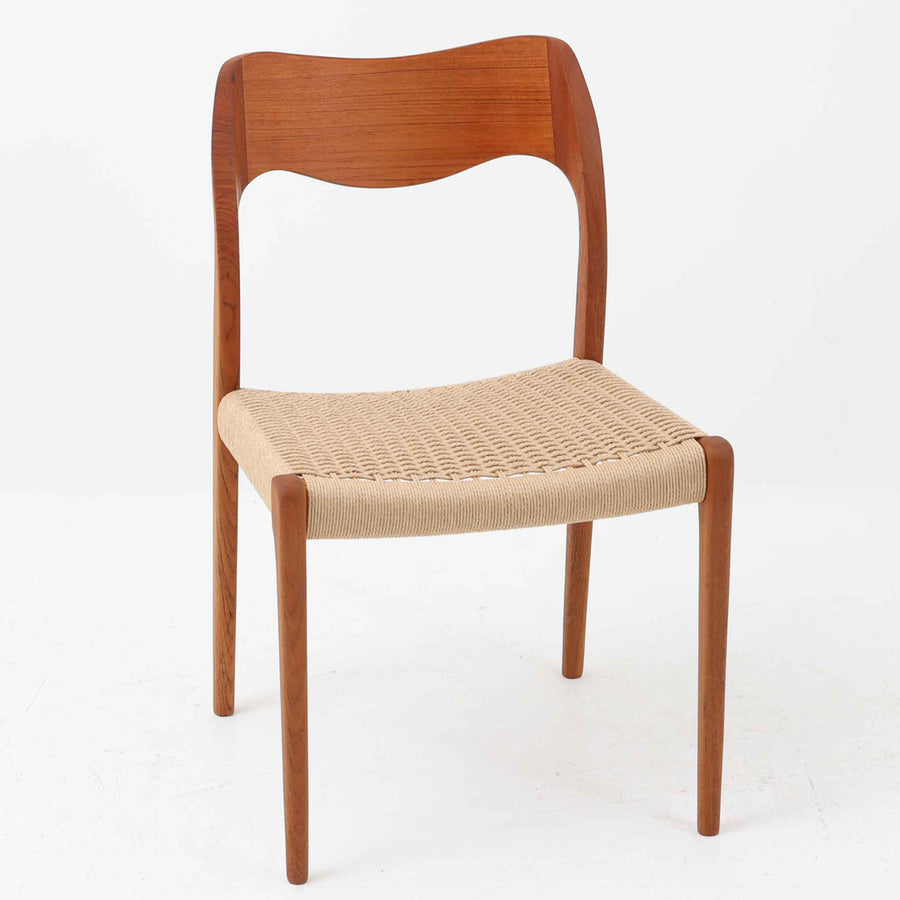 Niels Otto Mollerが手掛け、J.L. Mollers Mobelfabrik社によって製造されたModel 71は、チーク材とペーパーコードの美しい組み合わせが魅力の北欧ビンテージダイニングチェアです。背もたれから後脚へと流れるように繋がる柔らかな曲線が、身体を包み込むような快適な座り心地を生み出し、見た目にも優雅な印象を与えます。座面には職人の手作業によるペーパーコードが丁寧に張られ、自然素材ならではの温もりと耐久性を兼ね備えています。シンプルで洗練された佇まいは、ダイニングだけでなく書斎や玄関にも馴染みやすく、暮らしの中で長くご愛用いただける一脚です。ビンテージ品でのみ入手可能なチーク材のモデルです。
