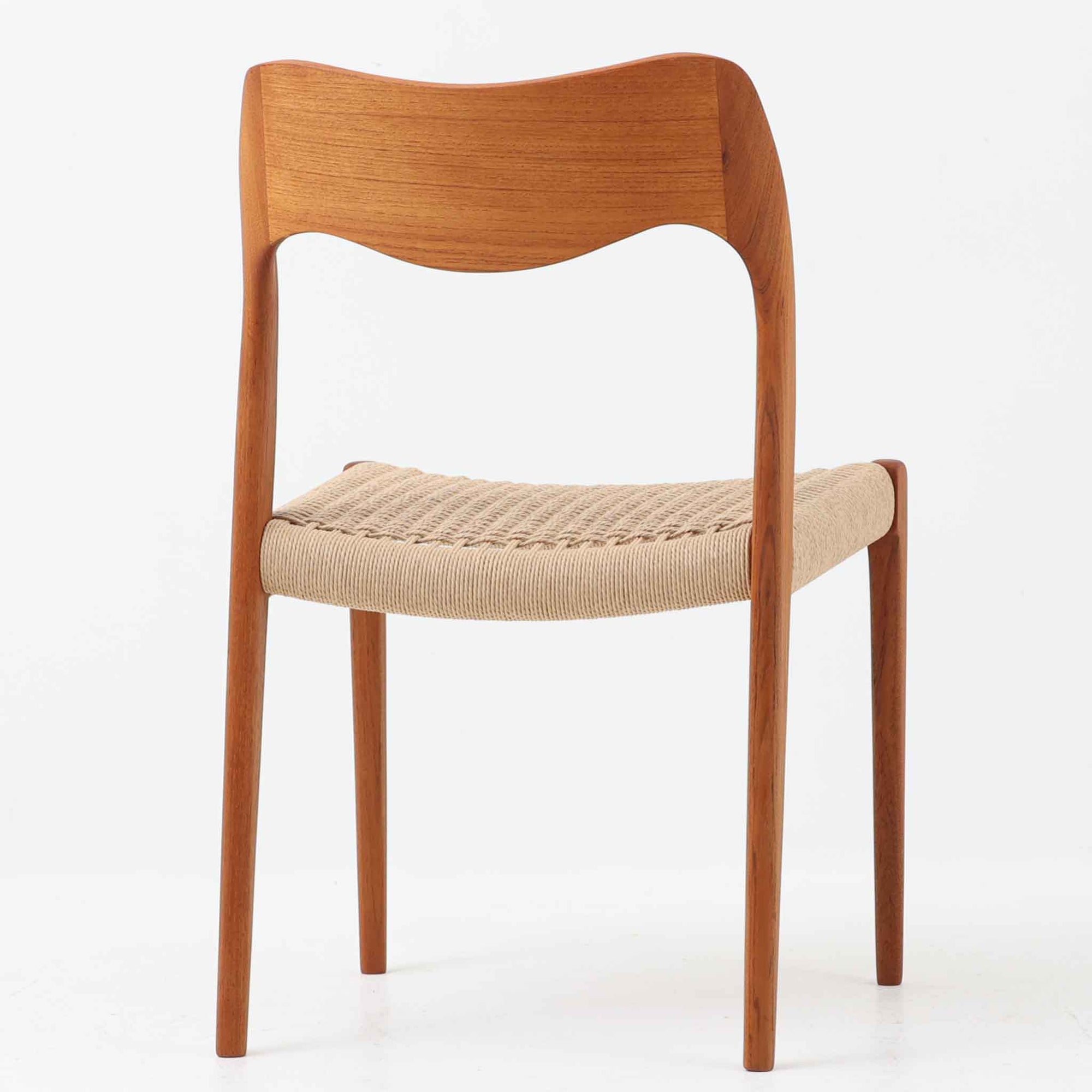 Niels Otto Mollerが手掛け、J.L. Mollers Mobelfabrik社によって製造されたModel 71は、チーク材とペーパーコードの美しい組み合わせが魅力の北欧ビンテージダイニングチェアです。背もたれから後脚へと流れるように繋がる柔らかな曲線が、身体を包み込むような快適な座り心地を生み出し、見た目にも優雅な印象を与えます。座面には職人の手作業によるペーパーコードが丁寧に張られ、自然素材ならではの温もりと耐久性を兼ね備えています。シンプルで洗練された佇まいは、ダイニングだけでなく書斎や玄関にも馴染みやすく、暮らしの中で長くご愛用いただける一脚です。ビンテージ品でのみ入手可能なチーク材のモデルです。