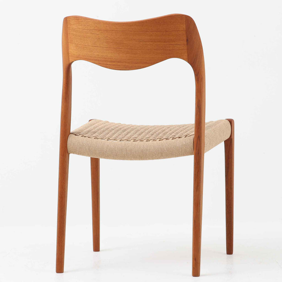 Niels Otto Mollerが手掛け、J.L. Mollers Mobelfabrik社によって製造されたModel 71は、チーク材とペーパーコードの美しい組み合わせが魅力の北欧ビンテージダイニングチェアです。背もたれから後脚へと流れるように繋がる柔らかな曲線が、身体を包み込むような快適な座り心地を生み出し、見た目にも優雅な印象を与えます。座面には職人の手作業によるペーパーコードが丁寧に張られ、自然素材ならではの温もりと耐久性を兼ね備えています。シンプルで洗練された佇まいは、ダイニングだけでなく書斎や玄関にも馴染みやすく、暮らしの中で長くご愛用いただける一脚です。ビンテージ品でのみ入手可能なチーク材のモデルです。