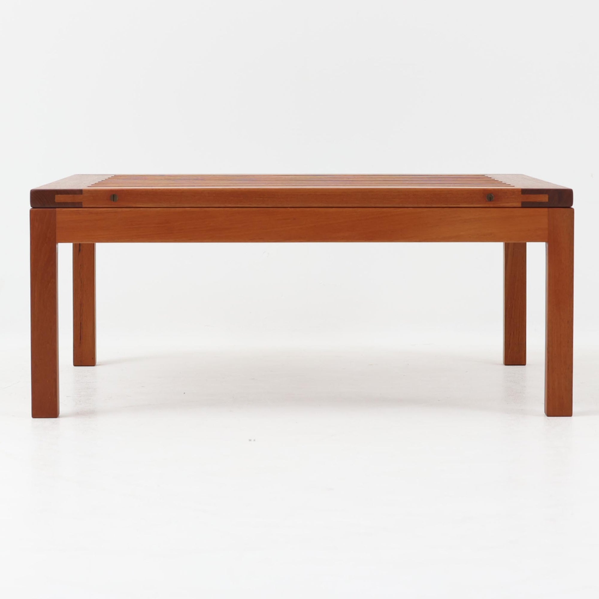 Hans J. Wegnerによってデザインされ、Andreas Tuck社が製造したこちらのセンターテーブルは、希少なチーク無垢材を贅沢に用いた北欧ビンテージ家具です。整然と並ぶスリット状の天板は、軽やかな印象と共に空間に抜け感を与え、視覚的にも機能的にも優れた構造美を感じさせます。幅70cmのコンパクトなサイズ感ながら、素材の質感や精緻な仕上げにウェグナーらしい美意識が宿り、空間に静かな存在感をもたらします。雑誌やトレイを使って工夫することで、リビングや書斎のテーブルとしても十分に活躍します。