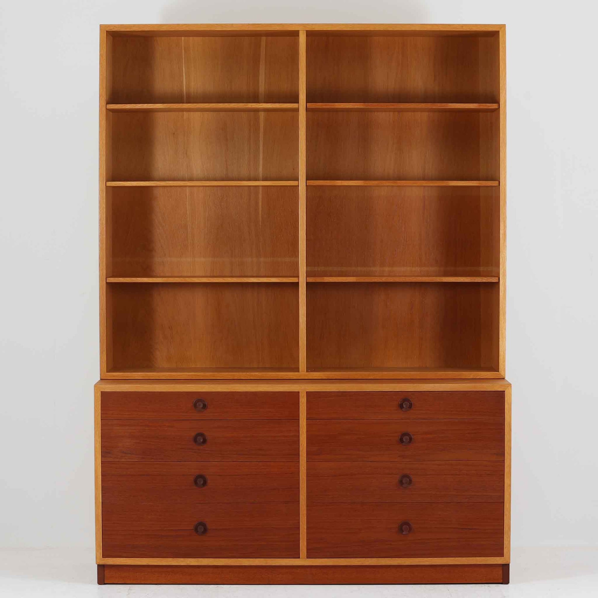 Borge Mogensenがデザインを手がけ、Karl Andersson社によって製造されたこちらのディスプレイシェルフは、チークとオークの異素材の美しいコントラストが際立つ北欧ビンテージ家具です。上段は可動式の棚板を備えたオープン収納、下段は左右に5杯ずつの引き出しを備え、収納力と機能性に優れた構成となっています。温かみのある木肌と丸型取手のアクセントが、空間に柔らかな印象を添えつつ、経年による風合いがヴィンテージらしい魅力を引き立てます。書斎やリビングでの書籍や雑貨の整理におすすめの一台です。