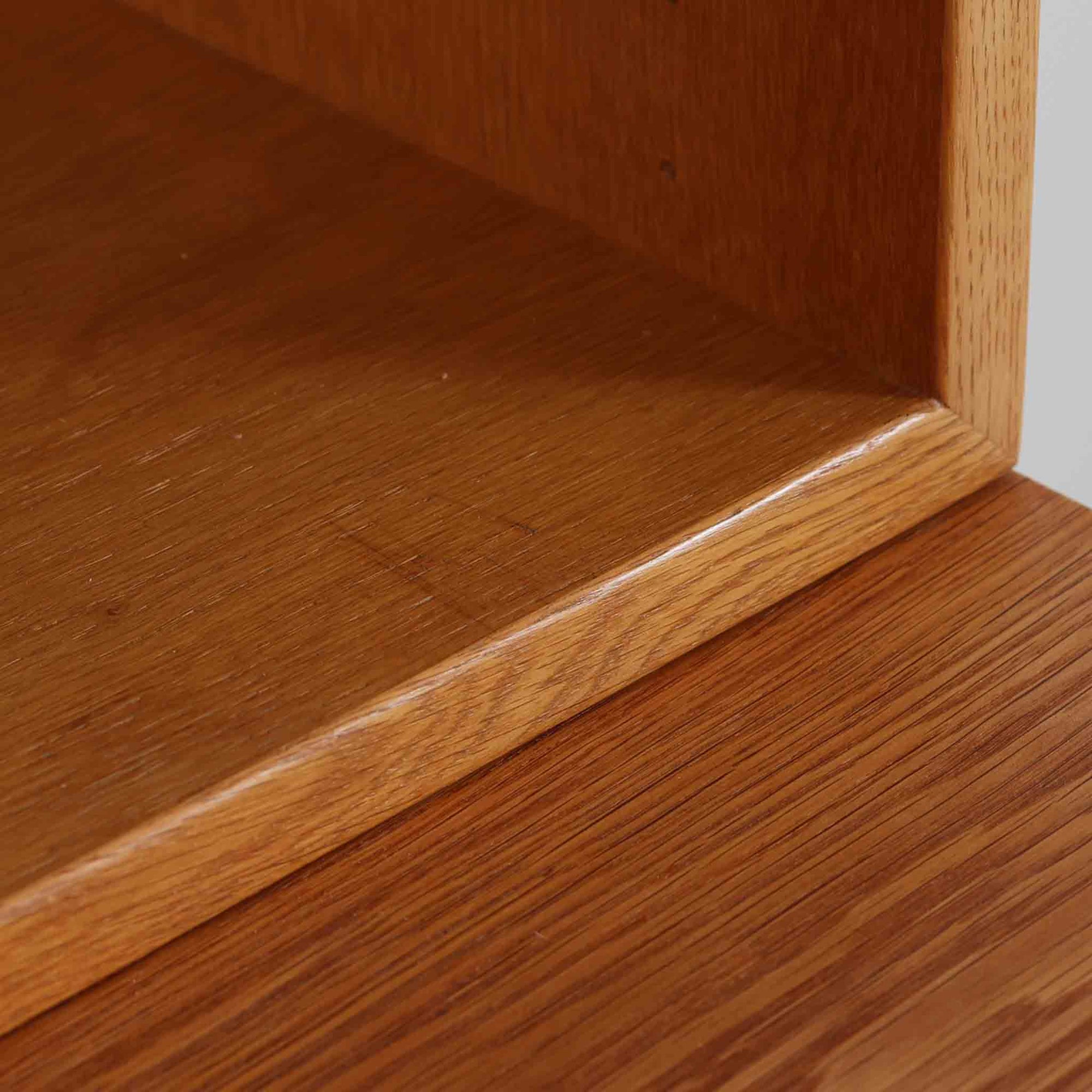 Borge Mogensenがデザインを手がけ、Karl Andersson社によって製造されたこちらのディスプレイシェルフは、チークとオークの異素材の美しいコントラストが際立つ北欧ビンテージ家具です。上段は可動式の棚板を備えたオープン収納、下段は左右に5杯ずつの引き出しを備え、収納力と機能性に優れた構成となっています。温かみのある木肌と丸型取手のアクセントが、空間に柔らかな印象を添えつつ、経年による風合いがヴィンテージらしい魅力を引き立てます。書斎やリビングでの書籍や雑貨の整理におすすめの一台です。