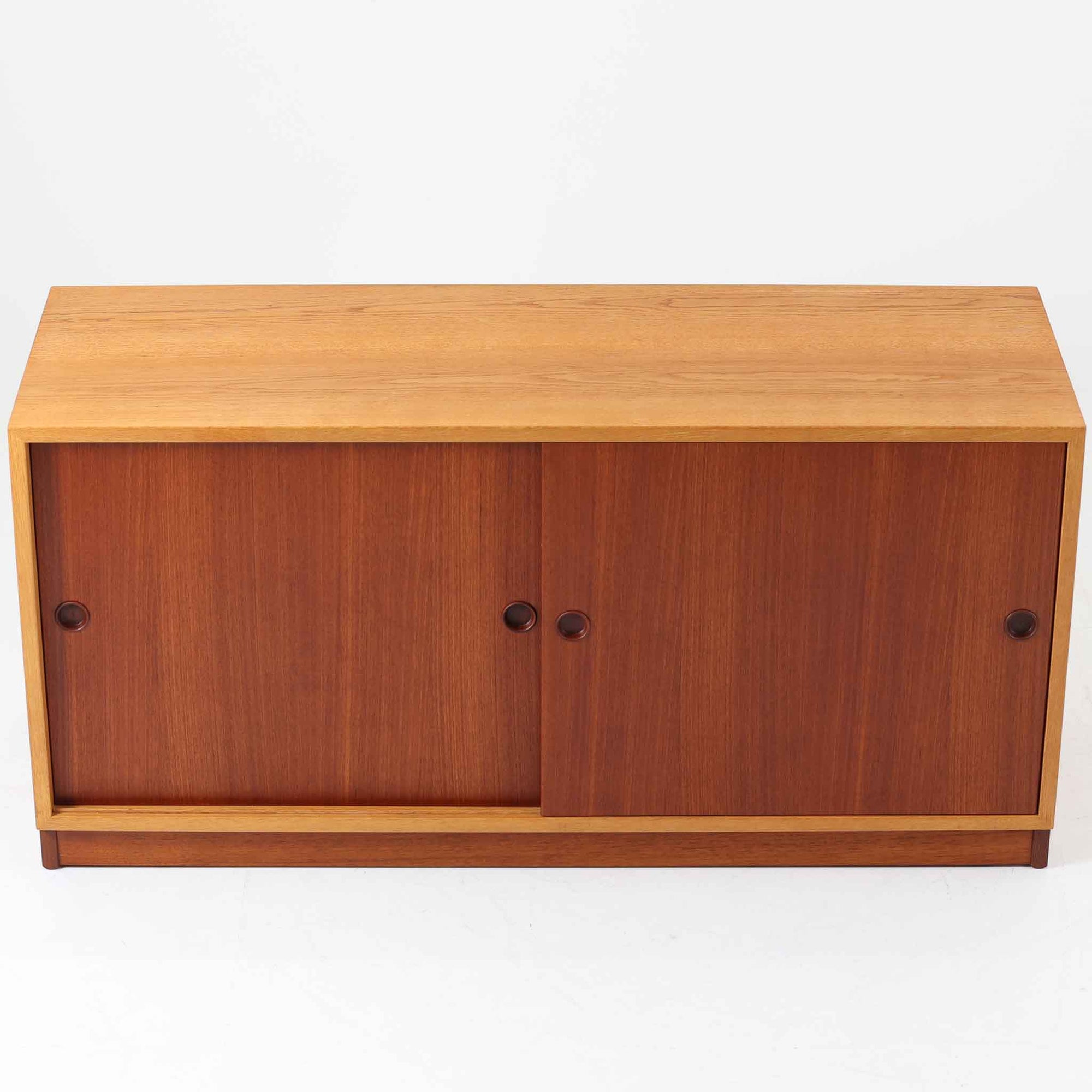 Borge Mogensenがデザインし、Karl Andersson社により製造されたこちらのディスプレイシェルフは、チーク材とオーク材のコントラストが美しいスウェーデン製の北欧ビンテージ家具です。上部はオープン構造で5段の棚が左右に配されており、書籍や器、小物のディスプレイに最適で、下部にはスライド扉収納も備え実用性にも優れています。幅135cmと存在感のあるサイズながら、直線的で端正な佇まいが空間に凛とした印象を与える一台です。