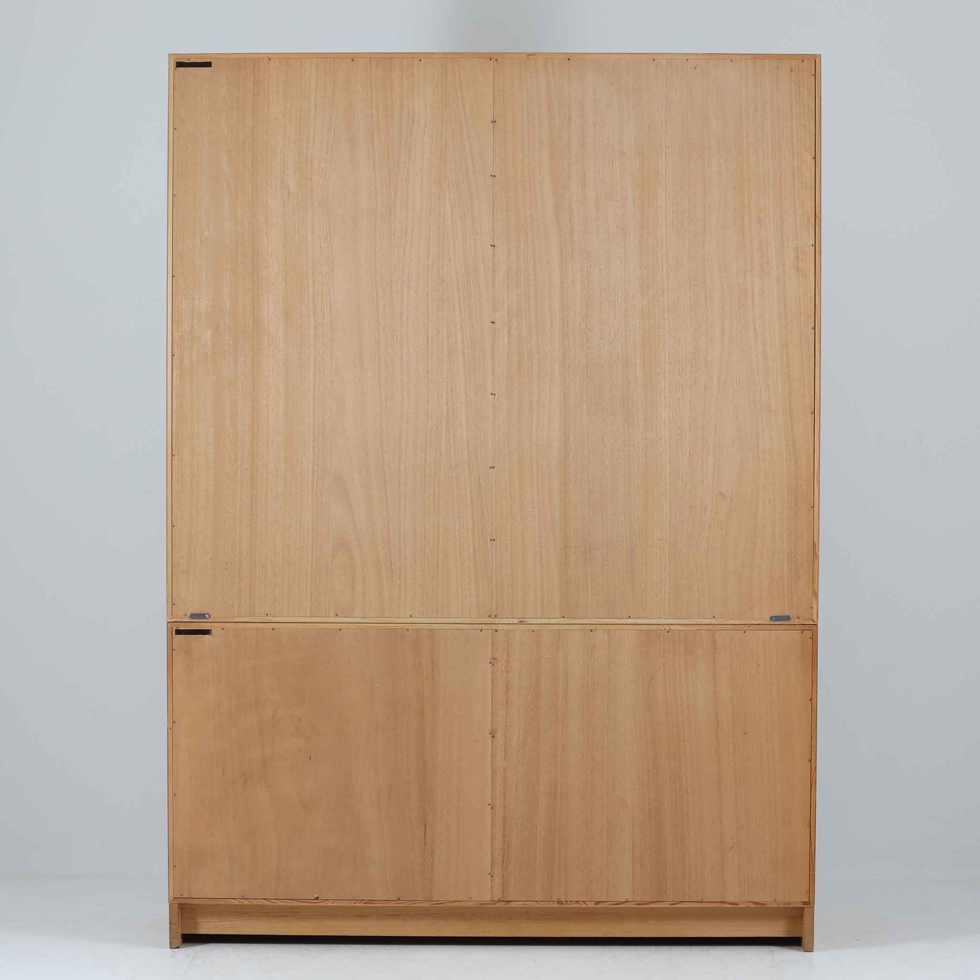 スウェーデンのKarl Andersson社より、Borge Mogensenによってデザインされたディスプレイシェルフは、端正な佇まいと機能性を兼ね備えた北欧ビンテージ家具です。オーク材の温もりある質感と美しい木目が魅力で、上段は可動棚付きのオープンシェルフ、下段には丸い掘り込み取手がアクセントとなった引き戸収納が配されています。文庫本や器、日用品の整理に最適で、暮らしの中で永く使い続けられる名作です。