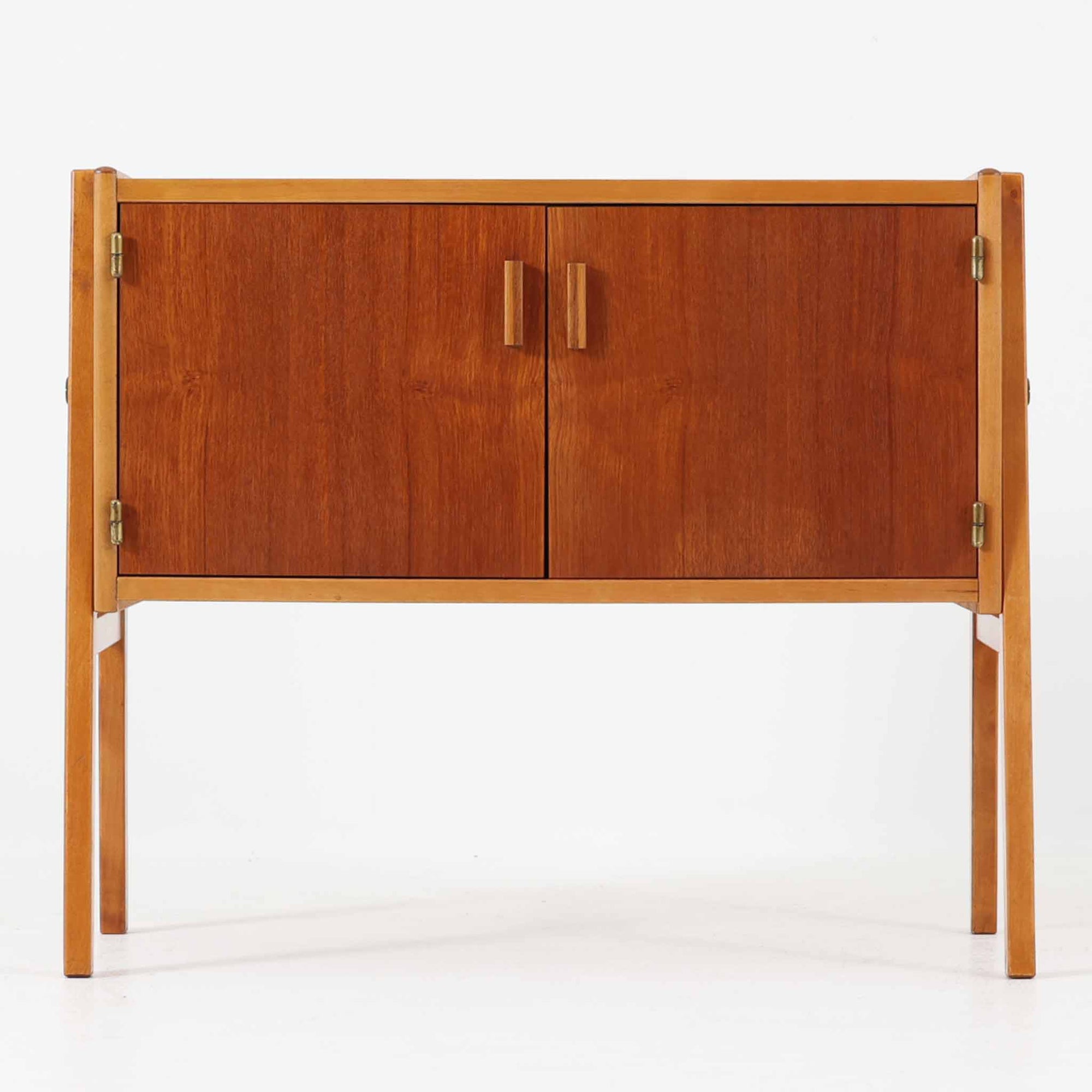 チーク材の扉とビーチ材のフレームがコントラストを成すこちらのキャビネットは、幅69cmの小ぶりなサイズ感ながらも北欧ビンテージらしい温かみと軽やかさを併せ持ち、すっきりとした直線的なフォルムと可動式の開き戸が空間に使いやすさとアクセントを加えます。玄関や寝室、リビングのサイド収納としても重宝する一台です。