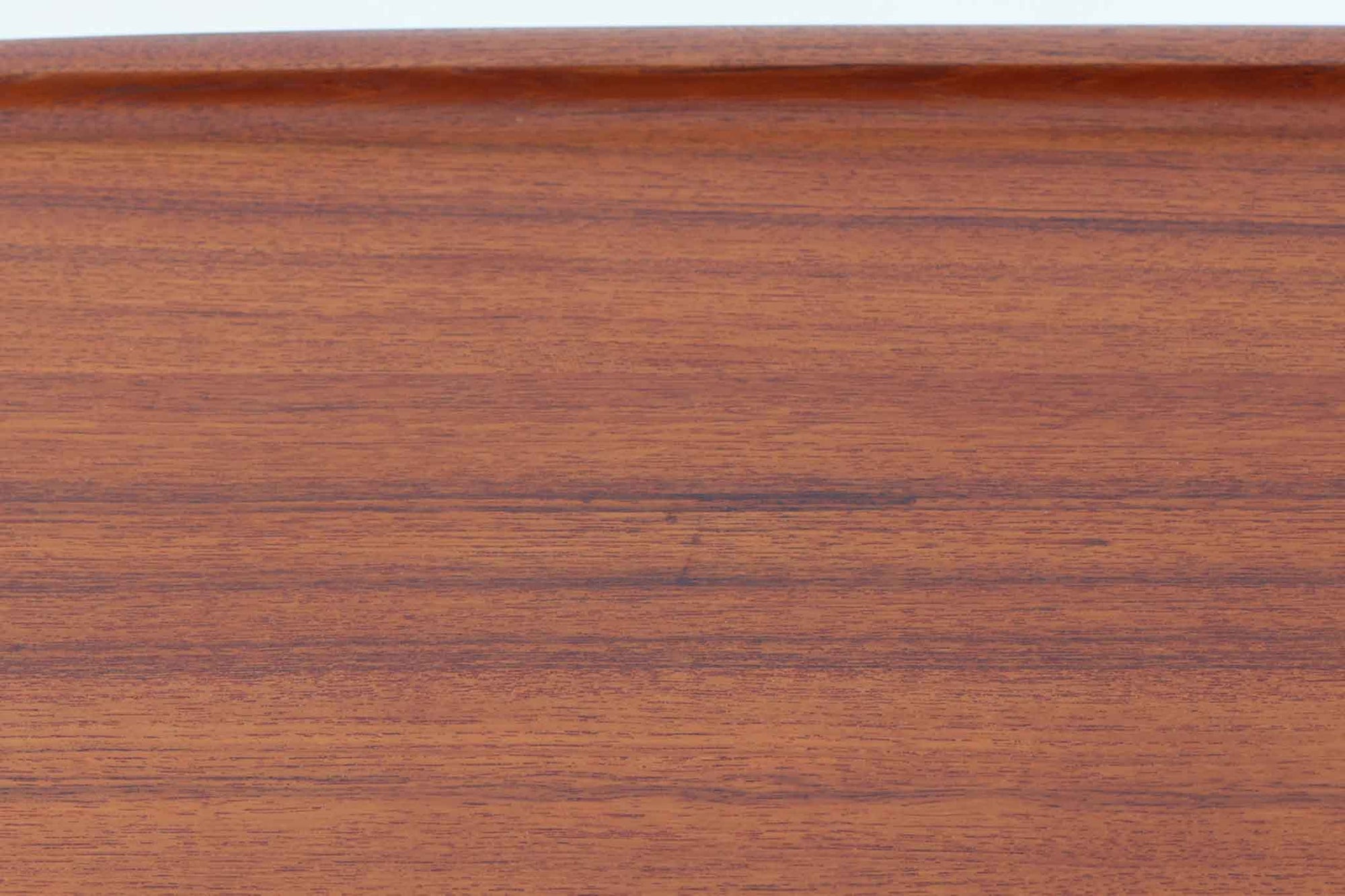 デンマークの女性デザイナー、グレーテ・ヤルクがデザインした1960年代のサイドテーブルです。Glostrup mobelfabrik社の製作による北欧モダンを代表する名作となっています。チーク材を贅沢に使用し、天板の緩やかな曲線と細身の脚部が美しいバランスを生み出しています。中段の横桟は、デザイン性と構造的な強度を両立。脚部は緩やかに外向きに設置され、安定感とエレガントさを兼ね備えています。コンパクトなサイズ感で、ソファサイドやベッドサイドなど様々な場所で活躍。現代のインテリアにも自然に溶け込む、時代を超えた普遍的なデザインの逸品です。