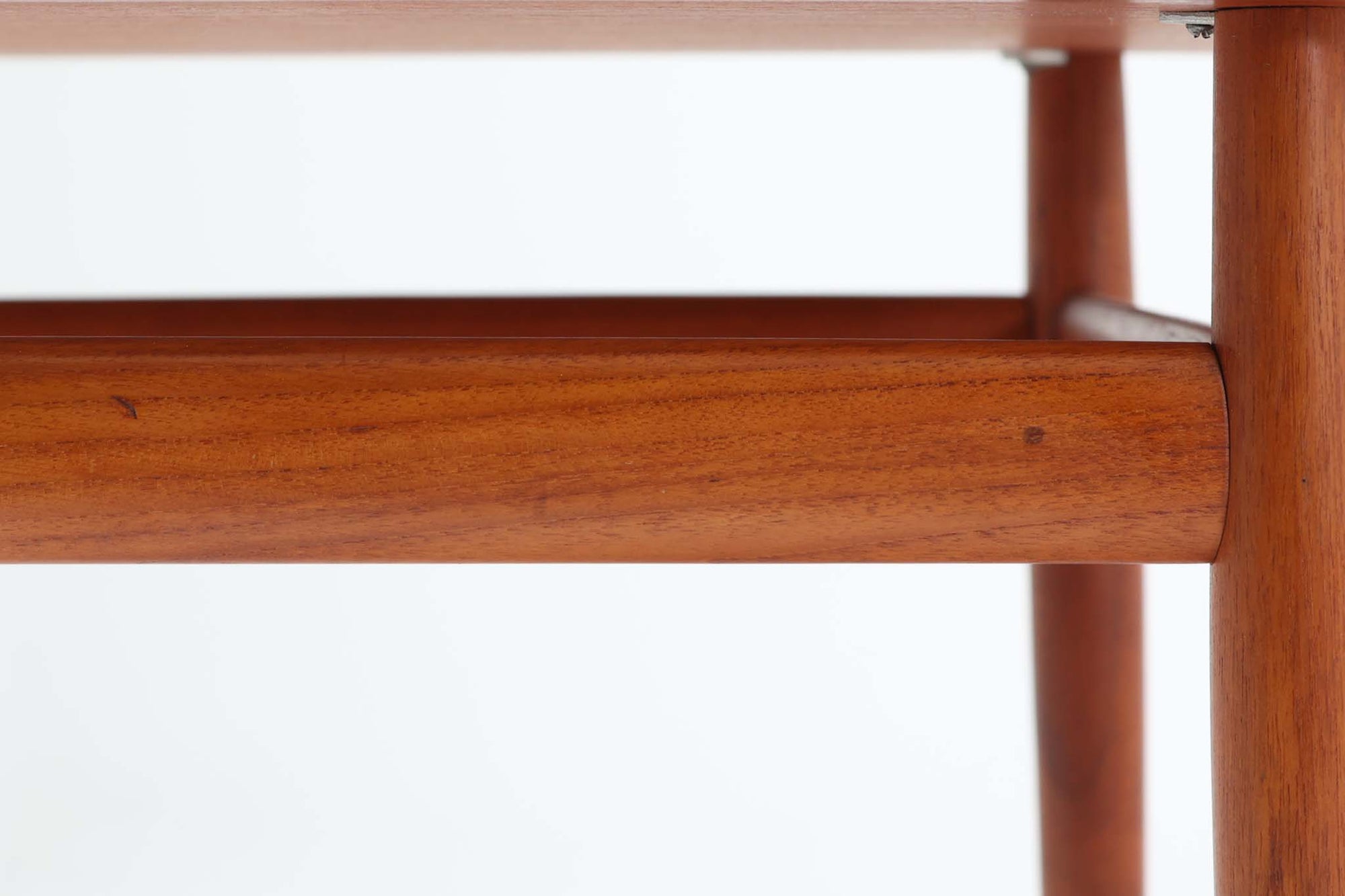 デンマークの女性デザイナー、グレーテ・ヤルクがデザインした1960年代のサイドテーブルです。Glostrup mobelfabrik社の製作による北欧モダンを代表する名作となっています。チーク材を贅沢に使用し、天板の緩やかな曲線と細身の脚部が美しいバランスを生み出しています。中段の横桟は、デザイン性と構造的な強度を両立。脚部は緩やかに外向きに設置され、安定感とエレガントさを兼ね備えています。コンパクトなサイズ感で、ソファサイドやベッドサイドなど様々な場所で活躍。現代のインテリアにも自然に溶け込む、時代を超えた普遍的なデザインの逸品です。