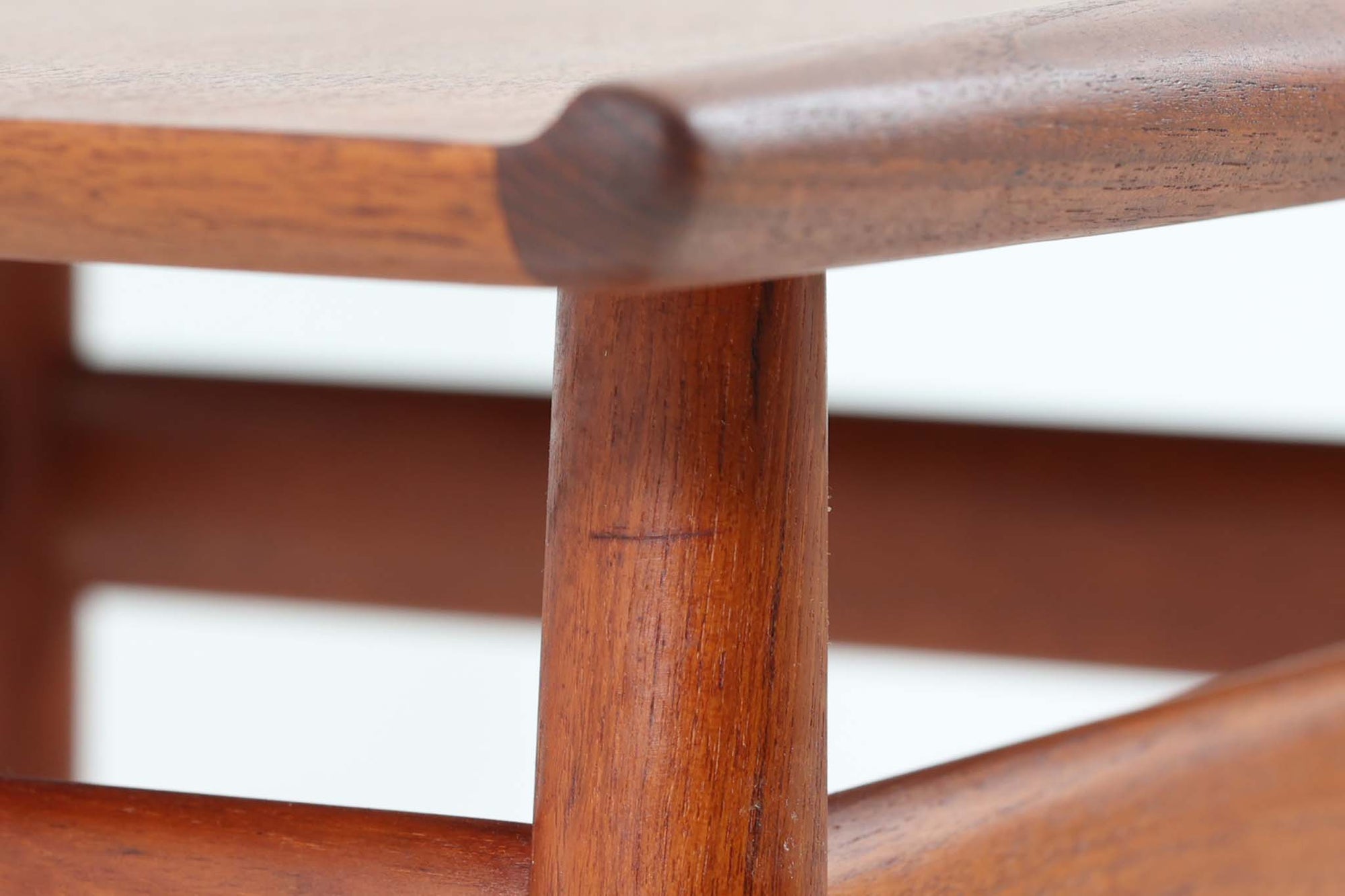 デンマークの女性デザイナー、グレーテ・ヤルクがデザインした1960年代のサイドテーブルです。Glostrup mobelfabrik社の製作による北欧モダンを代表する名作となっています。チーク材を贅沢に使用し、天板の緩やかな曲線と細身の脚部が美しいバランスを生み出しています。中段の横桟は、デザイン性と構造的な強度を両立。脚部は緩やかに外向きに設置され、安定感とエレガントさを兼ね備えています。コンパクトなサイズ感で、ソファサイドやベッドサイドなど様々な場所で活躍。現代のインテリアにも自然に溶け込む、時代を超えた普遍的なデザインの逸品です。