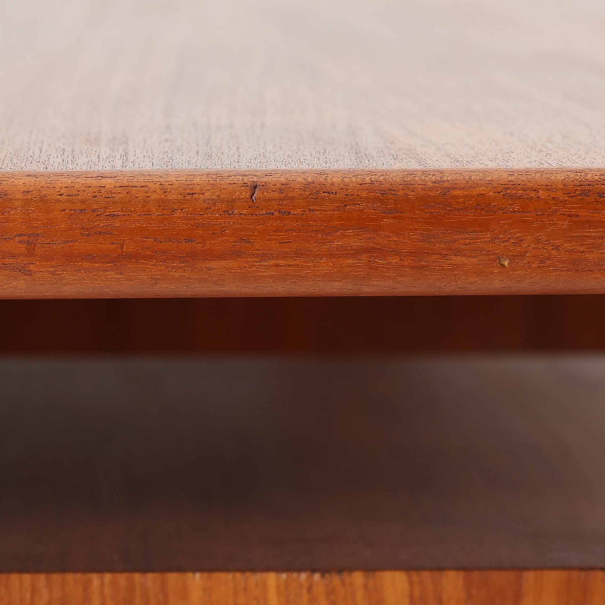 カイ・クリスチャンセンがデザインし、FM furniture社によって製造されたこちらの両袖デスクは、チーク材の美しい木目と温かみのある色合いが魅力の北欧ビンテージ家具です。左右には3杯ずつの引き出し、中央には扉付き収納を備え、背面にはオープンシェルフが設けられており、デスクとしての高い収納力と機能性を誇ります。壁付けはもちろん、間仕切りとしても活用できるため、空間の中心にも映える設計です。丸みを帯びた取手や脚部など、細部にまでこだわった意匠は、カイ・クリスチャンセンらしい洗練された美しさを体現しており、上質なワークスペースを演出します。