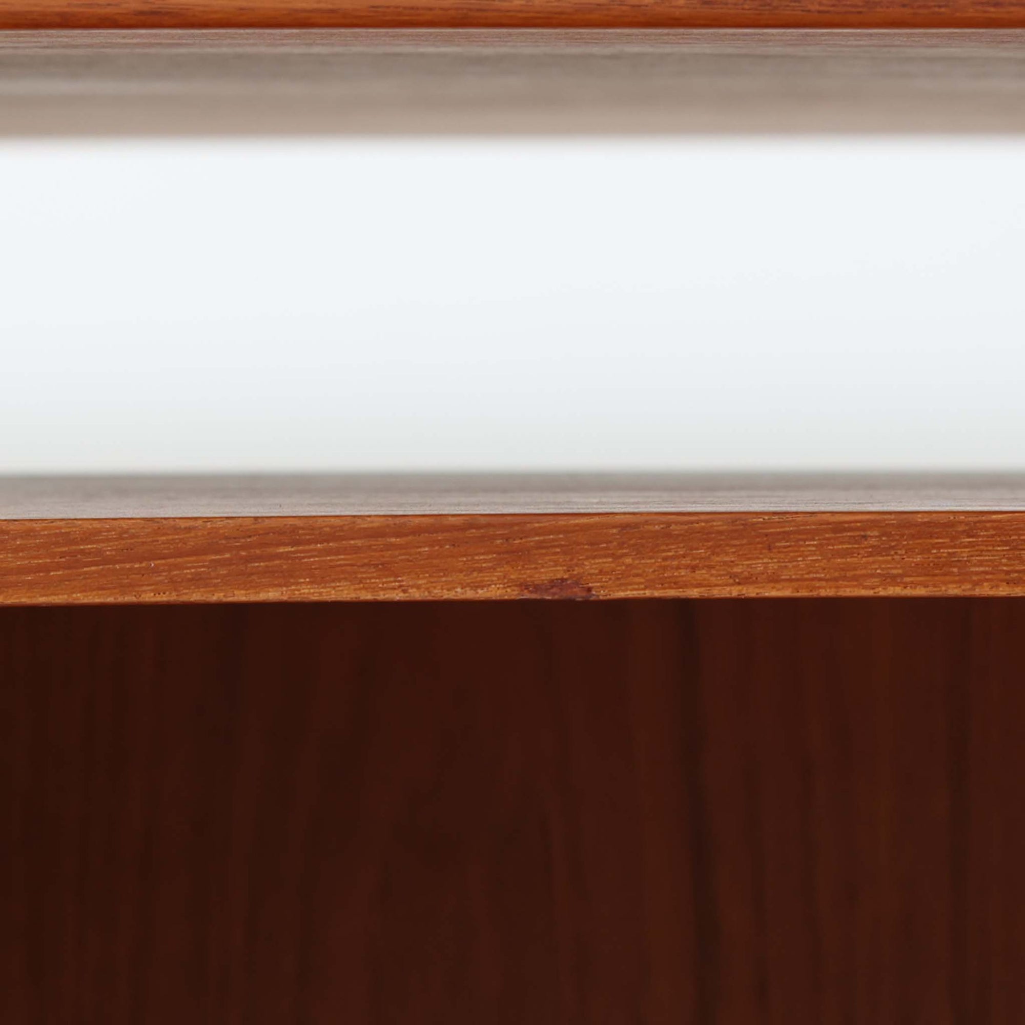 カイ・クリスチャンセンがデザインし、FM furniture社によって製造されたこちらの両袖デスクは、チーク材の美しい木目と温かみのある色合いが魅力の北欧ビンテージ家具です。左右には3杯ずつの引き出し、中央には扉付き収納を備え、背面にはオープンシェルフが設けられており、デスクとしての高い収納力と機能性を誇ります。壁付けはもちろん、間仕切りとしても活用できるため、空間の中心にも映える設計です。丸みを帯びた取手や脚部など、細部にまでこだわった意匠は、カイ・クリスチャンセンらしい洗練された美しさを体現しており、上質なワークスペースを演出します。