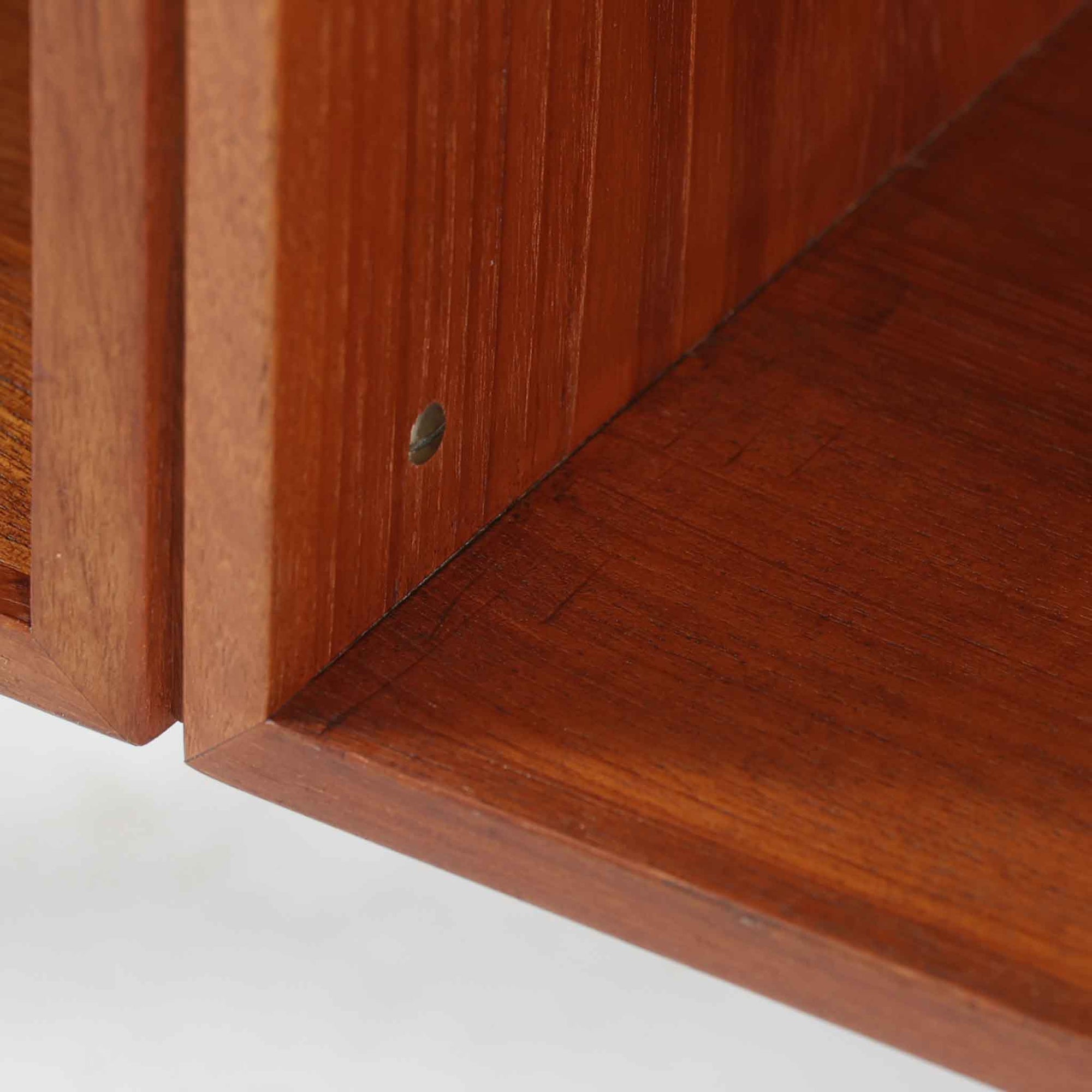 カイ・クリスチャンセンがデザインし、FM furniture社によって製造されたこちらの両袖デスクは、チーク材の美しい木目と温かみのある色合いが魅力の北欧ビンテージ家具です。左右には3杯ずつの引き出し、中央には扉付き収納を備え、背面にはオープンシェルフが設けられており、デスクとしての高い収納力と機能性を誇ります。壁付けはもちろん、間仕切りとしても活用できるため、空間の中心にも映える設計です。丸みを帯びた取手や脚部など、細部にまでこだわった意匠は、カイ・クリスチャンセンらしい洗練された美しさを体現しており、上質なワークスペースを演出します。