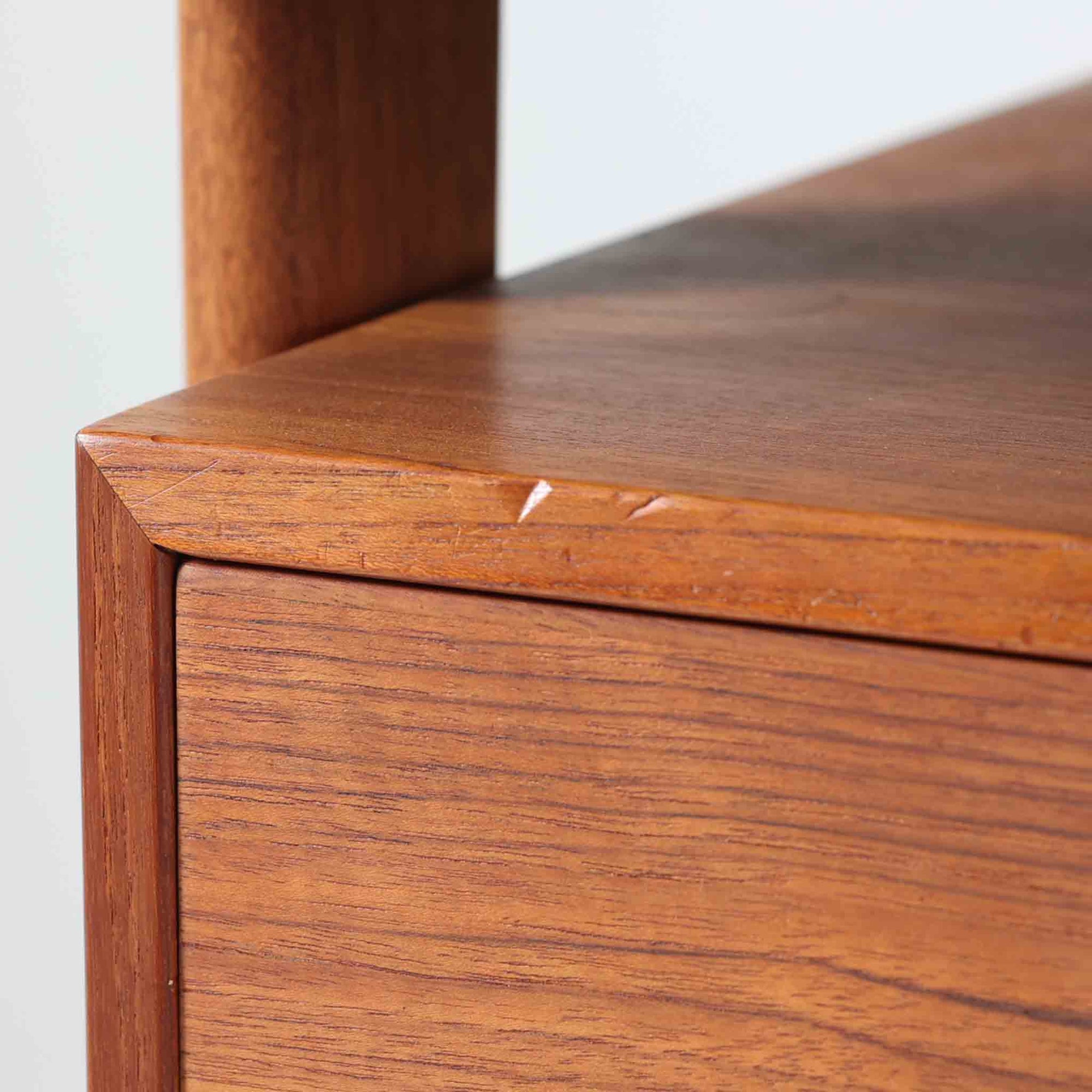 カイ・クリスチャンセンがデザインし、FM furniture社によって製造されたこちらの両袖デスクは、チーク材の美しい木目と温かみのある色合いが魅力の北欧ビンテージ家具です。左右には3杯ずつの引き出し、中央には扉付き収納を備え、背面にはオープンシェルフが設けられており、デスクとしての高い収納力と機能性を誇ります。壁付けはもちろん、間仕切りとしても活用できるため、空間の中心にも映える設計です。丸みを帯びた取手や脚部など、細部にまでこだわった意匠は、カイ・クリスチャンセンらしい洗練された美しさを体現しており、上質なワークスペースを演出します。