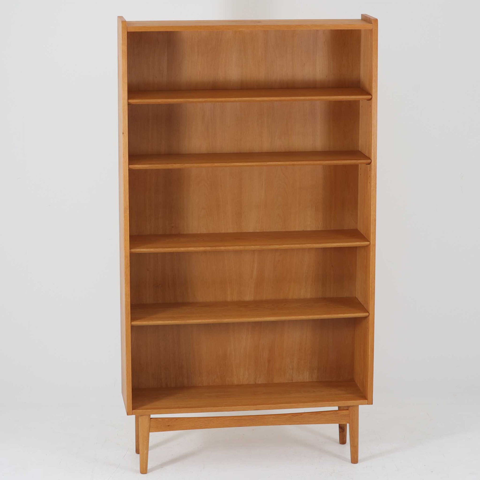 Johannes Sorthがデザインし、Bornholms Mobelfabrik社から1965年に製造されたこちらのブックシェルフは、美しい木目のオーク材と縦長のすっきりとしたフォルムが印象的な北欧ビンテージ家具で、豊富な棚板が本や雑貨の収納に優れた実用性を発揮します。裏面には「29 JUNI 1965」の刻印が残されており、当時のクラフトマンシップを感じさせる趣深い一台です。