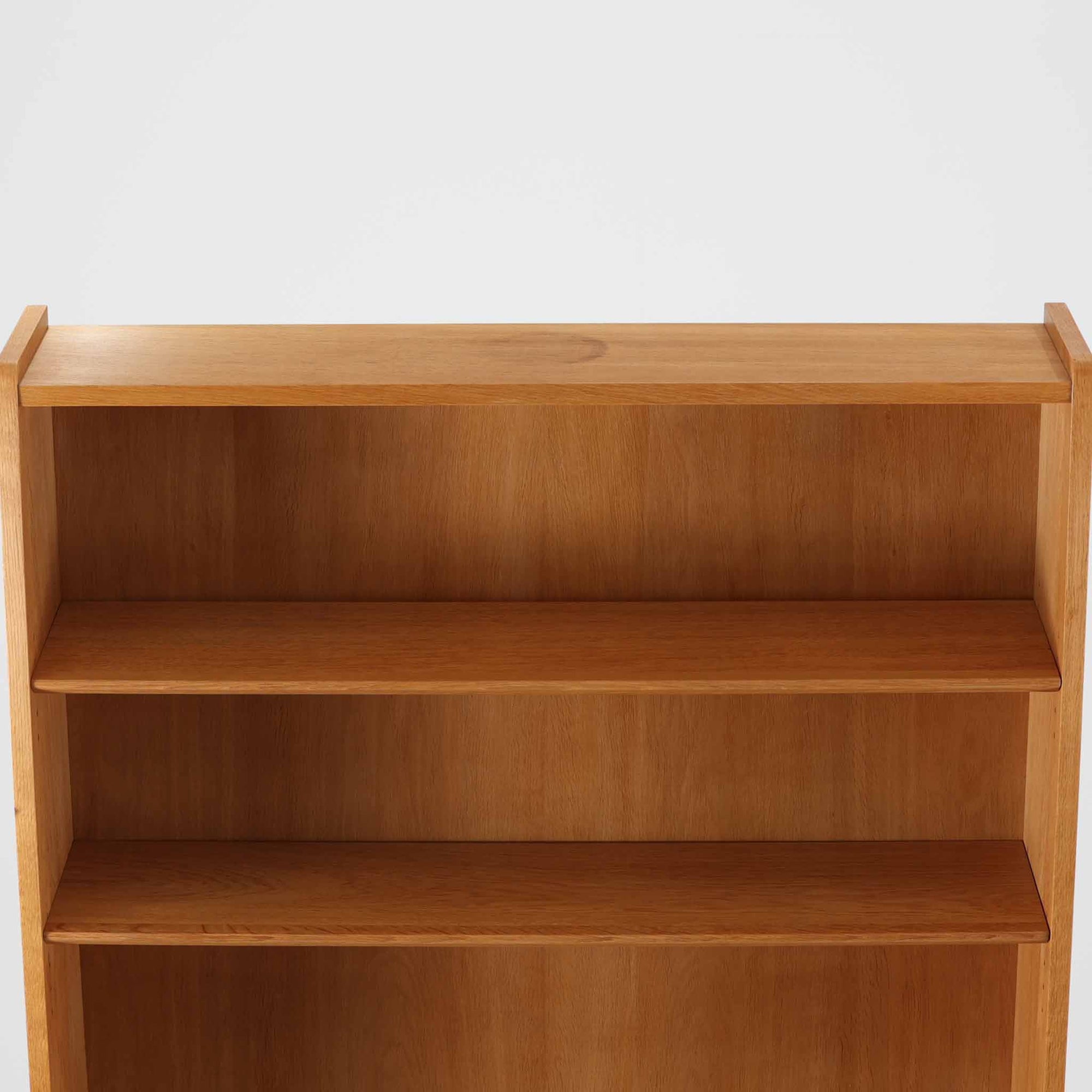 Johannes Sorthがデザインし、Bornholms Mobelfabrik社から1965年に製造されたこちらのブックシェルフは、美しい木目のオーク材と縦長のすっきりとしたフォルムが印象的な北欧ビンテージ家具で、豊富な棚板が本や雑貨の収納に優れた実用性を発揮します。裏面には「29 JUNI 1965」の刻印が残されており、当時のクラフトマンシップを感じさせる趣深い一台です。
