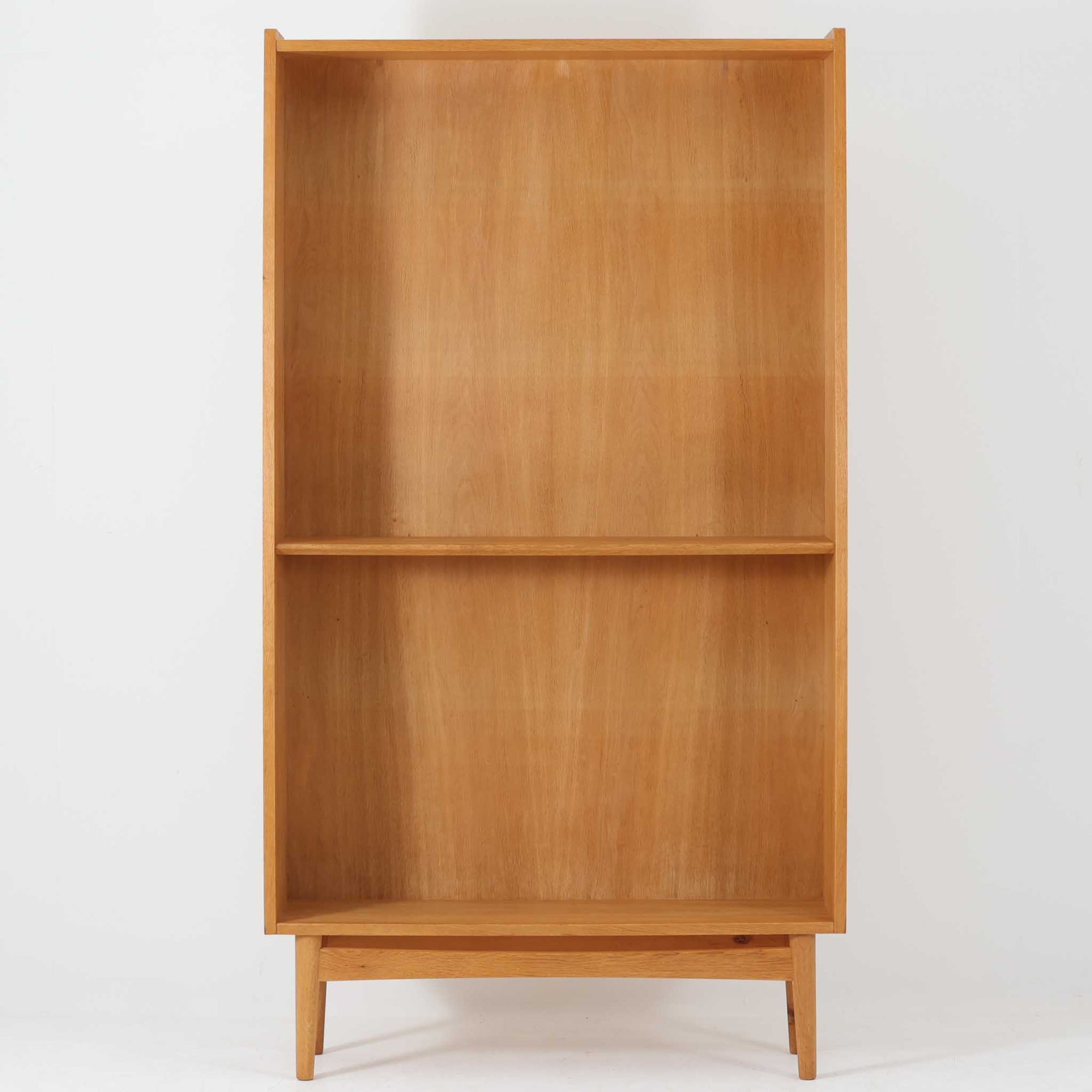 Johannes Sorthがデザインし、Bornholms Mobelfabrik社から1965年に製造されたこちらのブックシェルフは、美しい木目のオーク材と縦長のすっきりとしたフォルムが印象的な北欧ビンテージ家具で、豊富な棚板が本や雑貨の収納に優れた実用性を発揮します。裏面には「29 JUNI 1965」の刻印が残されており、当時のクラフトマンシップを感じさせる趣深い一台です。