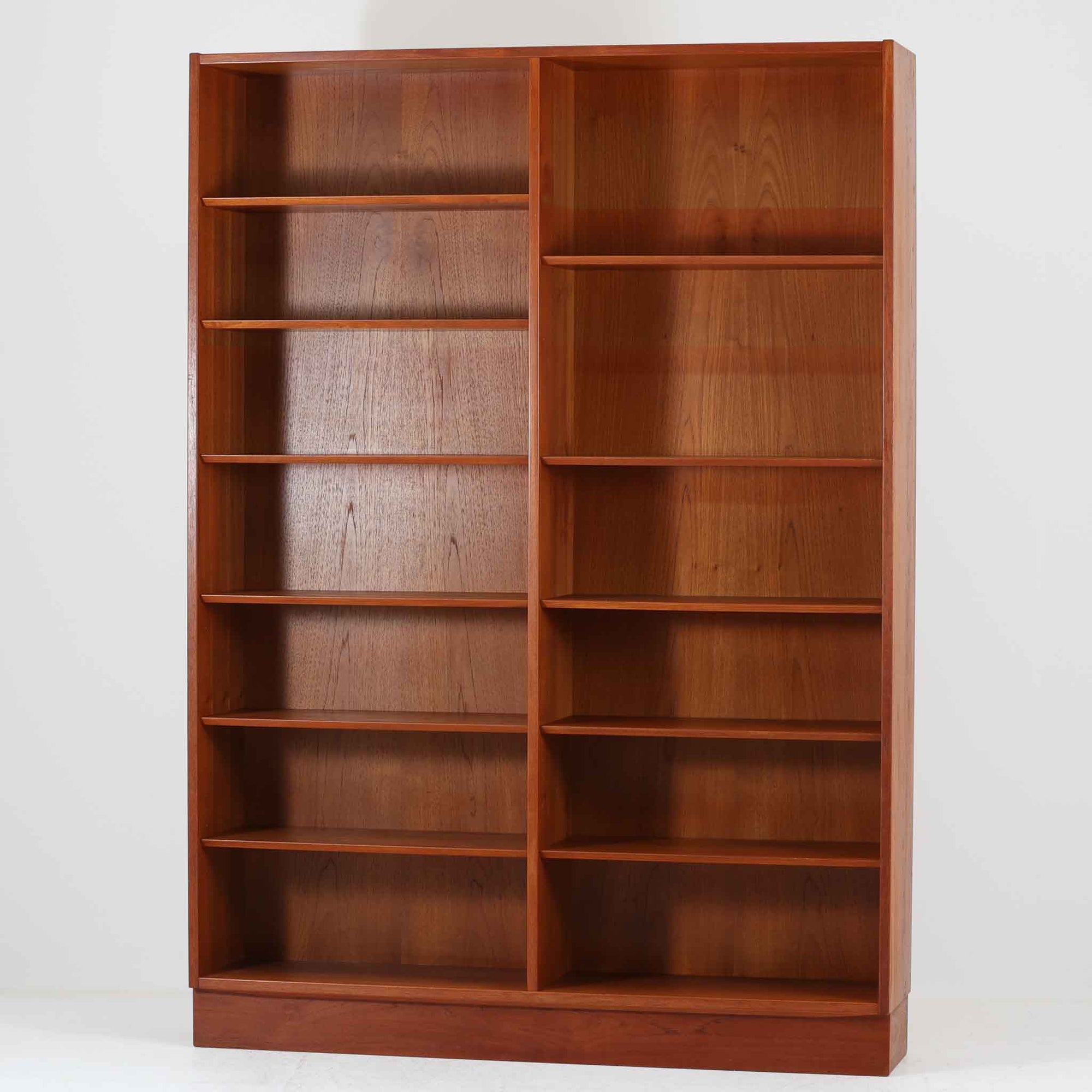 Poul Hundevadがデザインし、Hundevad & Co社によって製造されたこちらの大型ブックシェルフは、幅139cmの堂々としたサイズと美しいチーク材の木目が印象的な北欧ビンテージ家具です。12段の棚構成により書籍やコレクションの収納に優れ、棚板は取り外し可能で用途に応じた柔軟なレイアウトが可能です。背面にはDanish ControlとHundevadの刻印が残されており、デザイン性と品質の高さを物語る一台です。シンプルながらも洗練された佇まいは、リビングや書斎の主役としても存在感を放ちます。