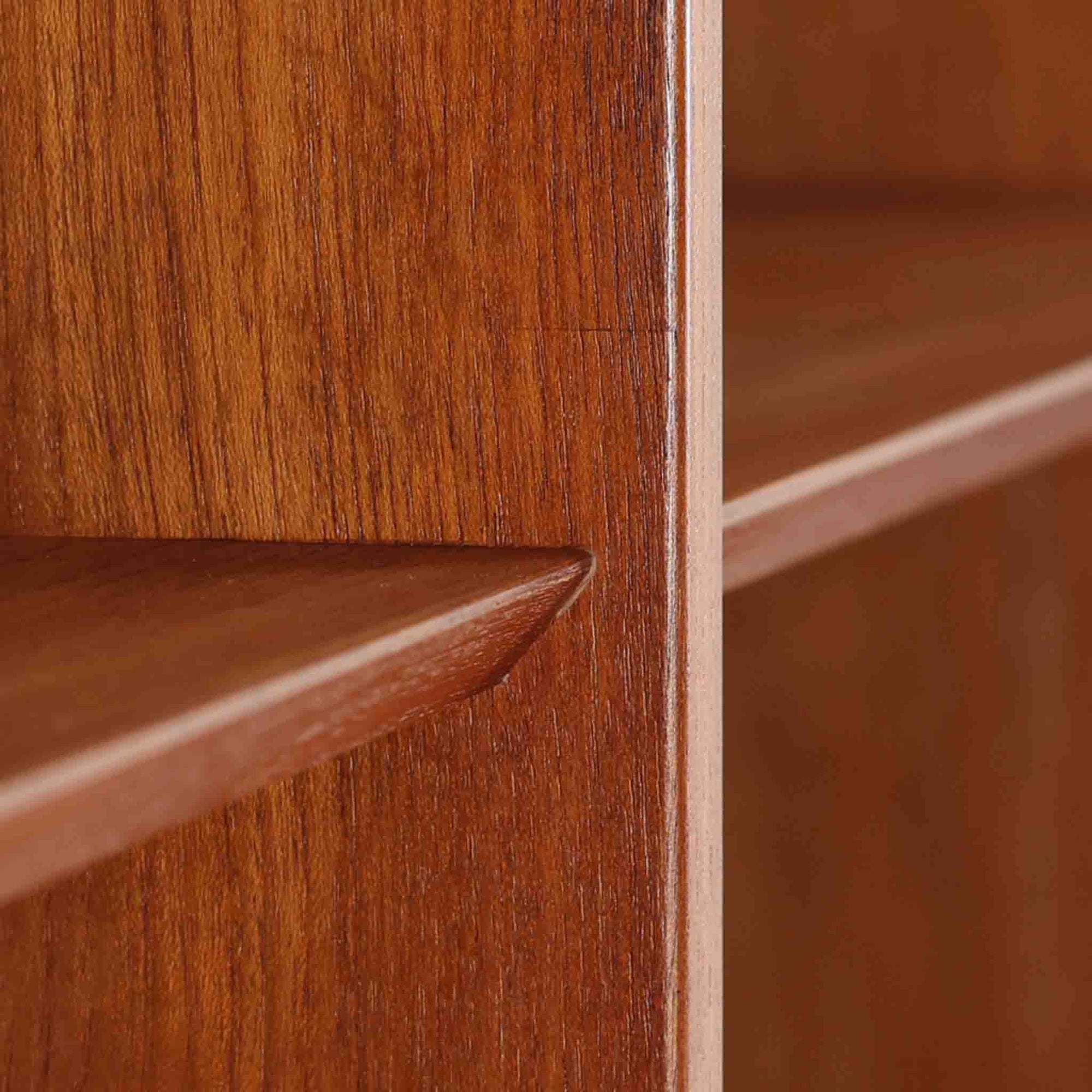 Poul Hundevadがデザインし、Hundevad &amp; Co社によって製造されたこちらの大型ブックシェルフは、幅139cmの堂々としたサイズと美しいチーク材の木目が印象的な北欧ビンテージ家具です。12段の棚構成により書籍やコレクションの収納に優れ、棚板は取り外し可能で用途に応じた柔軟なレイアウトが可能です。背面にはDanish ControlとHundevadの刻印が残されており、デザイン性と品質の高さを物語る一台です。シンプルながらも洗練された佇まいは、リビングや書斎の主役としても存在感を放ちます。