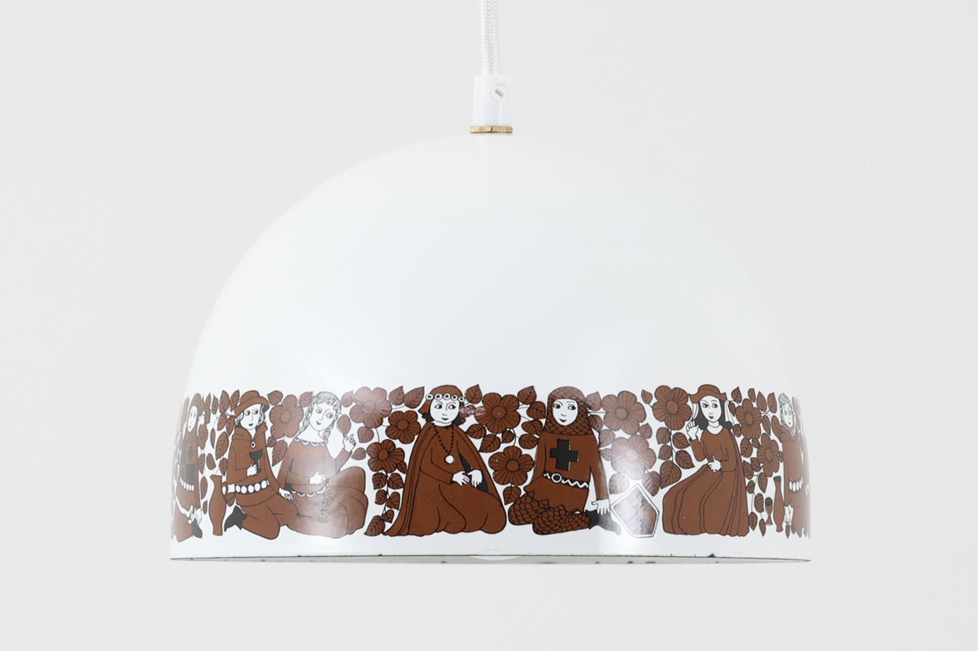 フィンランドの名窯ARABIA（アラビア）社によるRITARI（リタリ）シリーズのビンテージランプシェードです。柔らかなカーブを描くドーム型のフォルムは、フィンランドモダンを代表するデザイナーKaj Franck（カイ・フランク）によるもので、花と人物が描かれた印象的な装飾はRaija Uosikkinen（ライヤ・ウオシッキネン）によってデザインされました。RITARIはフィンランド語で「騎士」を意味し、中世の衣装をまとった人物たちが、ブラウンを基調とした花々とともにシェードをぐるりと囲むユニークでノスタルジックなデザインが特徴です。素材はホーロー（琺瑯）製で、しっかりとした重量感と経年による独特の風合いも楽しめるアイテム。点灯時にはやわらかな光を下方向に届け、空間に温もりを添えてくれます。北欧らしいストーリー性とデザイン性を併せ持った、希少なビンテージ照明をお探しの方におすすめです。