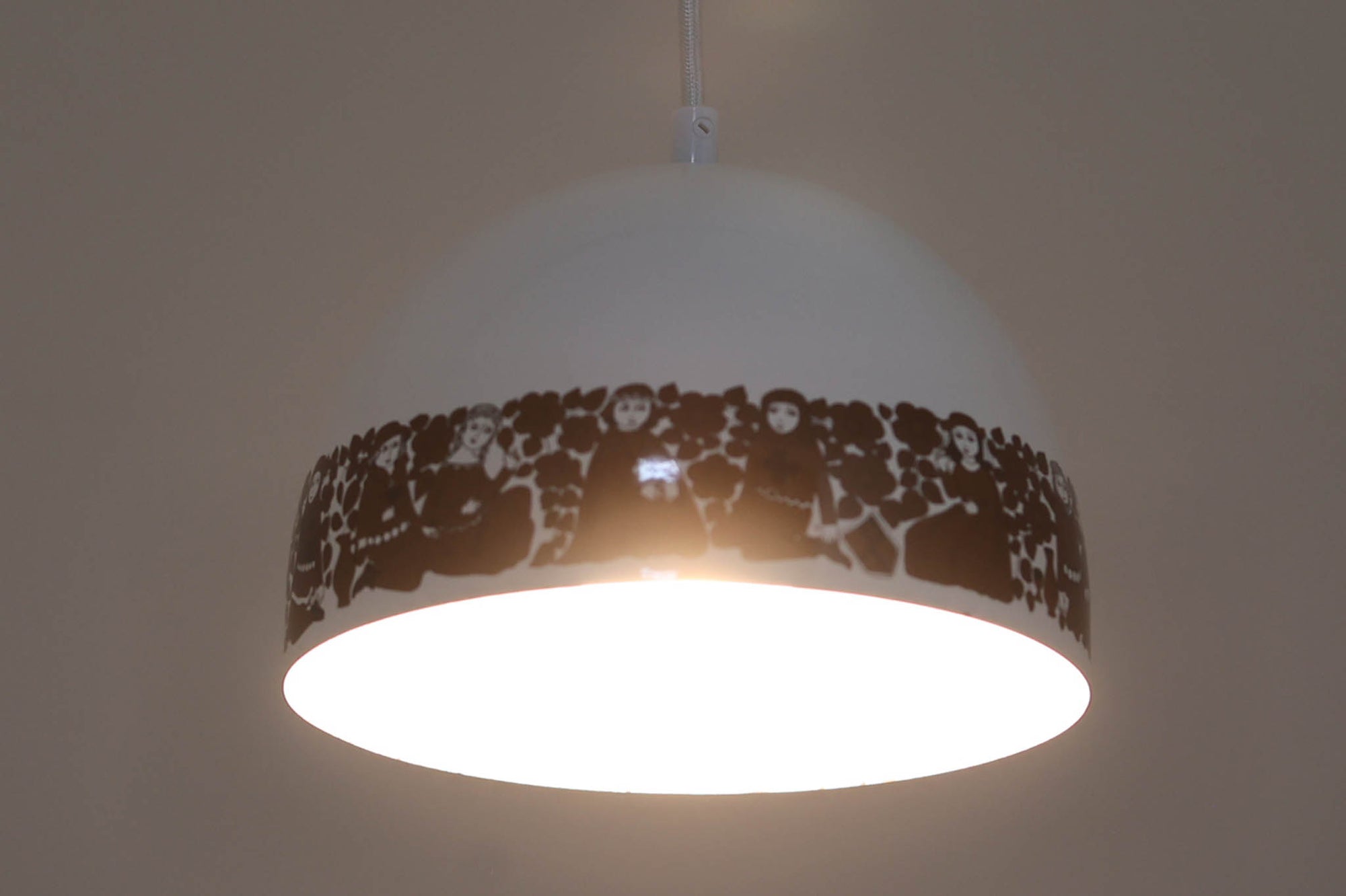 フィンランドの名窯ARABIA（アラビア）社によるRITARI（リタリ）シリーズのビンテージランプシェードです。柔らかなカーブを描くドーム型のフォルムは、フィンランドモダンを代表するデザイナーKaj Franck（カイ・フランク）によるもので、花と人物が描かれた印象的な装飾はRaija Uosikkinen（ライヤ・ウオシッキネン）によってデザインされました。RITARIはフィンランド語で「騎士」を意味し、中世の衣装をまとった人物たちが、ブラウンを基調とした花々とともにシェードをぐるりと囲むユニークでノスタルジックなデザインが特徴です。素材はホーロー（琺瑯）製で、しっかりとした重量感と経年による独特の風合いも楽しめるアイテム。点灯時にはやわらかな光を下方向に届け、空間に温もりを添えてくれます。北欧らしいストーリー性とデザイン性を併せ持った、希少なビンテージ照明をお探しの方におすすめです。