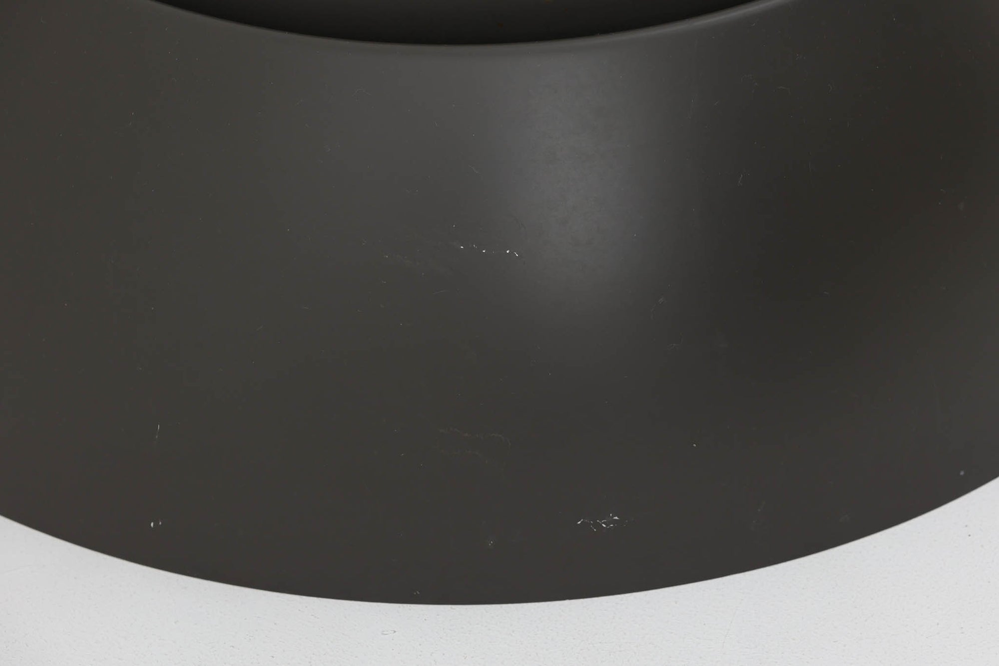 アルネ・ヤコブセンによってデザインされ、Louis Poulsen（ルイスポールセン）より製造されたAJロイヤル ペンダントライト。こちらは希少なグラファイトグレーカラーで、落ち着いたトーンが空間にシックな雰囲気を演出します。直径50cmの大型サイズで、光源を遮る構造と放射状に配置されたルーバーにより、眩しさを抑えた柔らかい光が空間全体を包み込みます。点灯時には上部のスリットから漏れる光も美しく、デザイン性と機能性を兼ね備えた一品です。外観には小傷や使用感がありますが、ビンテージならではの風合いとしてお楽しみいただけます。