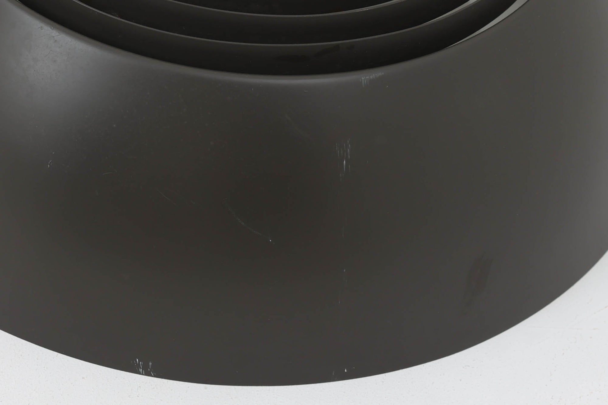 アルネ・ヤコブセンによってデザインされ、Louis Poulsen（ルイスポールセン）より製造されたAJロイヤル ペンダントライト。こちらは希少なグラファイトグレーカラーで、落ち着いたトーンが空間にシックな雰囲気を演出します。直径50cmの大型サイズで、光源を遮る構造と放射状に配置されたルーバーにより、眩しさを抑えた柔らかい光が空間全体を包み込みます。点灯時には上部のスリットから漏れる光も美しく、デザイン性と機能性を兼ね備えた一品です。外観には小傷や使用感がありますが、ビンテージならではの風合いとしてお楽しみいただけます。