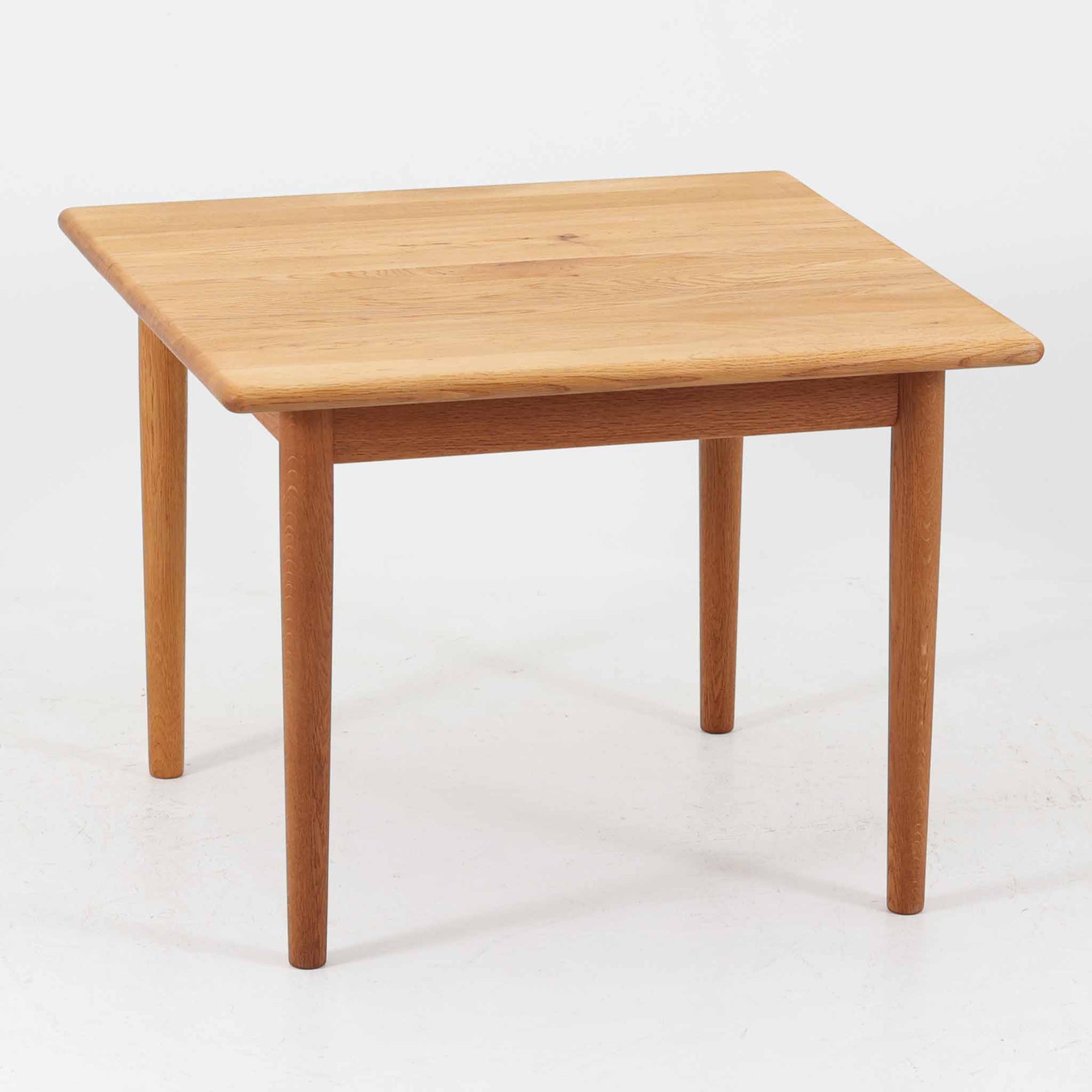 Hans J. WegnerがデザインしGetama社より製造されたGE80/86センターテーブルは、オーク無垢材を贅沢に使用した堅牢かつ端正な一台です。丸みを帯びた天板の縁や、すっきりとした円錐形の脚部が特徴で、シンプルでありながら温かみのある北欧デザインを体現しています。幅75cmと扱いやすいサイズ感で、リビングの中心に置いてコーヒーテーブルとしてはもちろん、サイドに添えても活躍する汎用性の高い家具です。経年による木肌の変化が深みを増し、ビンテージならではの存在感を放ちます。