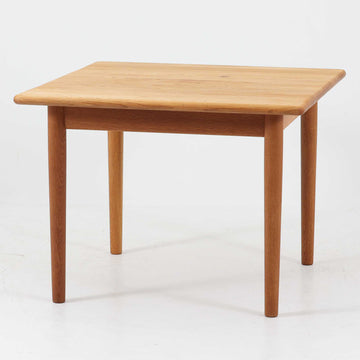 Hans J. WegnerがデザインしGetama社より製造されたGE80/86センターテーブルは、オーク無垢材を贅沢に使用した堅牢かつ端正な一台です。丸みを帯びた天板の縁や、すっきりとした円錐形の脚部が特徴で、シンプルでありながら温かみのある北欧デザインを体現しています。幅75cmと扱いやすいサイズ感で、リビングの中心に置いてコーヒーテーブルとしてはもちろん、サイドに添えても活躍する汎用性の高い家具です。経年による木肌の変化が深みを増し、ビンテージならではの存在感を放ちます。