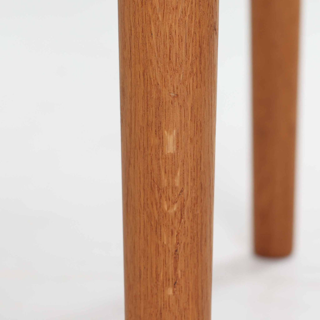 Hans J. WegnerがデザインしGetama社より製造されたGE80/86センターテーブルは、オーク無垢材を贅沢に使用した堅牢かつ端正な一台です。丸みを帯びた天板の縁や、すっきりとした円錐形の脚部が特徴で、シンプルでありながら温かみのある北欧デザインを体現しています。幅75cmと扱いやすいサイズ感で、リビングの中心に置いてコーヒーテーブルとしてはもちろん、サイドに添えても活躍する汎用性の高い家具です。経年による木肌の変化が深みを増し、ビンテージならではの存在感を放ちます。