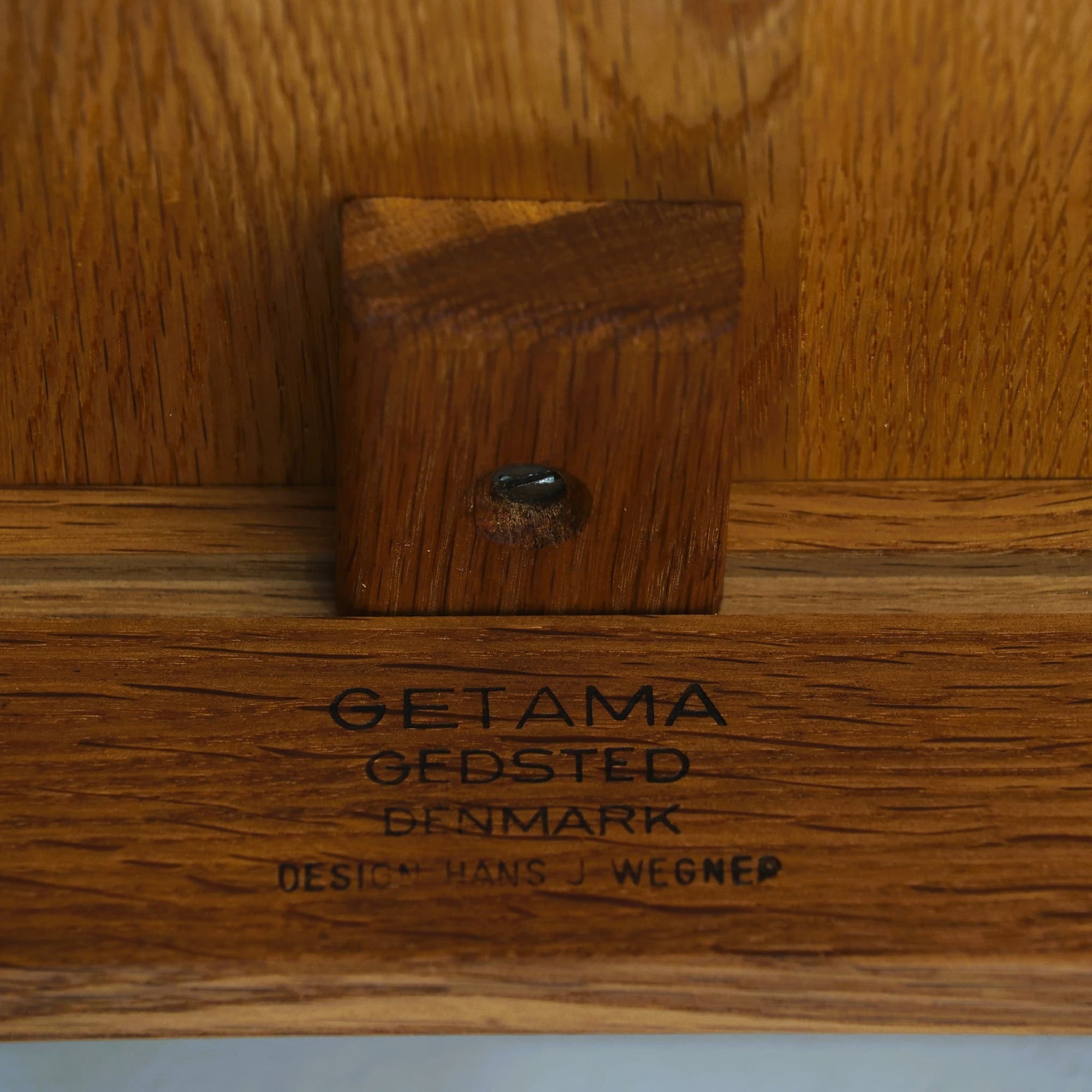 Hans J. WegnerがデザインしGetama社より製造されたGE80/86センターテーブルは、オーク無垢材を贅沢に使用した堅牢かつ端正な一台です。丸みを帯びた天板の縁や、すっきりとした円錐形の脚部が特徴で、シンプルでありながら温かみのある北欧デザインを体現しています。幅75cmと扱いやすいサイズ感で、リビングの中心に置いてコーヒーテーブルとしてはもちろん、サイドに添えても活躍する汎用性の高い家具です。経年による木肌の変化が深みを増し、ビンテージならではの存在感を放ちます。