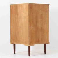 三角形のユニークなフォルムが目を引くこちらのコーナーキャビネットは、デンマーク製の北欧ビンテージ家具です。チーク材の温もりある木肌と、鍵付きのシンメトリーな扉が上品な佇まいを演出します。内部には棚板が2枚設けられており、日用品や雑貨などの収納に実用的。空間の角にすっきりと収まる設計は、デッドスペースを活かしながら、インテリアに程よいアクセントを加えてくれます。シンプルながら希少性を感じさせる一台です。