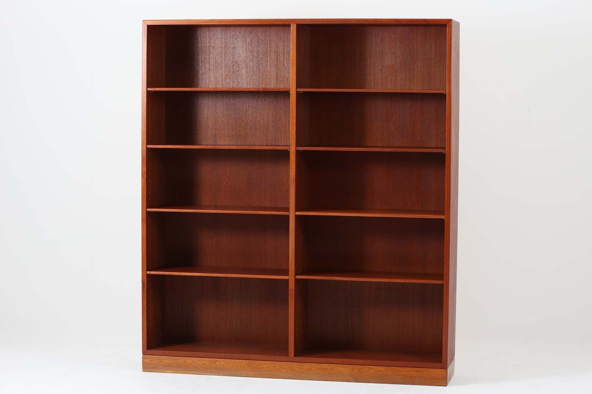 デンマークを代表するデザイナー、Borge mogensenがFDB社のために手がけたブックシェルフ。本体には上品な木目が魅力のチーク材を、土台部分には明るい色味のオーク材を採用しており、異なる材種の美しいコントラストが際立ちます。全体は無駄のないシンプルな構成ながら、細部にわたって丁寧な造り込みが施され、モーエンセンらしい機能性と静かな美しさが感じられる一台です。棚板は可動式で、本やオブジェの高さに合わせて自在にレイアウトが可能。収納力に優れつつも圧迫感のない佇まいで、リビングや書斎、寝室など幅広い空間に馴染みます。