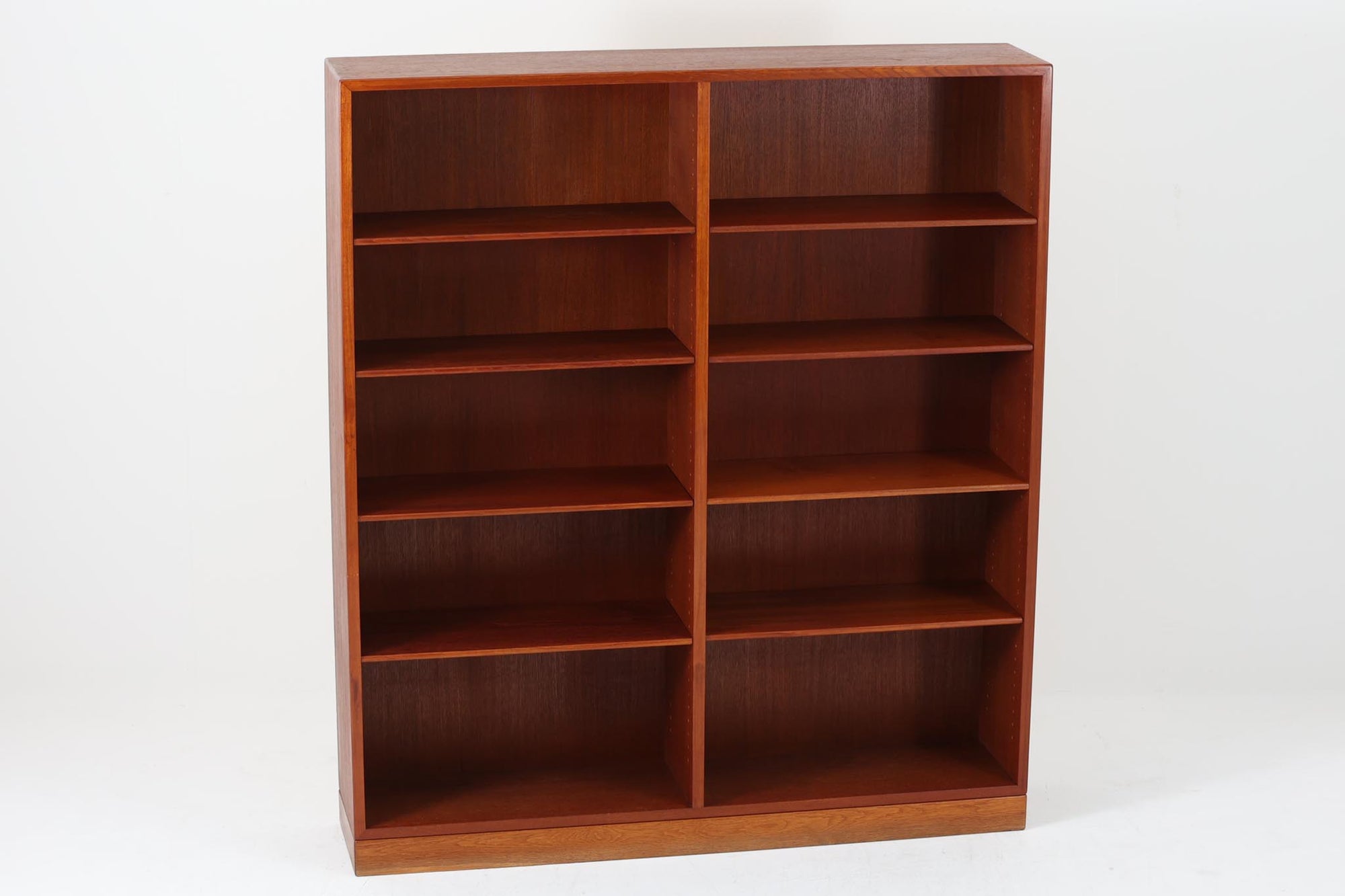 デンマークを代表するデザイナー、Borge mogensenがFDB社のために手がけたブックシェルフ。本体には上品な木目が魅力のチーク材を、土台部分には明るい色味のオーク材を採用しており、異なる材種の美しいコントラストが際立ちます。全体は無駄のないシンプルな構成ながら、細部にわたって丁寧な造り込みが施され、モーエンセンらしい機能性と静かな美しさが感じられる一台です。棚板は可動式で、本やオブジェの高さに合わせて自在にレイアウトが可能。収納力に優れつつも圧迫感のない佇まいで、リビングや書斎、寝室など幅広い空間に馴染みます。