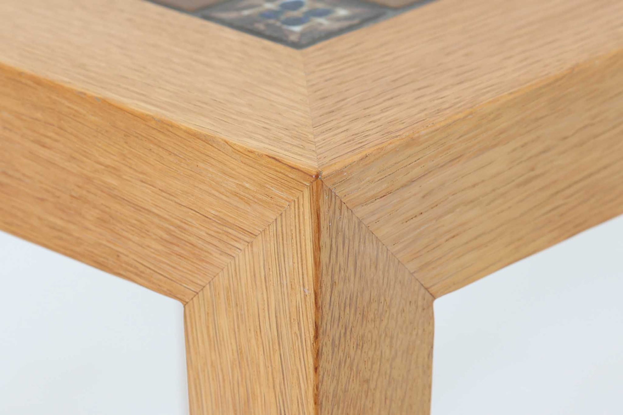 デンマークの家具デザイナー、Severin Hansen Jr.によってデザインされたビンテージのサイドテーブルです。製造はデンマークの名門家具メーカー「Haslev（ハスレヴ）」社。天板にはRoyal Copenhagen（ロイヤルコペンハーゲン）のアートタイルが贅沢にあしらわれています。タイルはNils Thorsson（ニルス・トーソン）が手掛けた人気の「BACA（バッカ）」シリーズ。象徴的なブルーとブラウンの色使いと、有機的かつ幾何学的なモチーフが印象的で、アートピースとしての存在感を放ちます。テーブル本体はオーク材を使用しており、Severin Hansen Jr.の特徴でもあるシャープなカットが施されたコーナーと、すっきりとしたテーパードレッグが、シンプルながら洗練された美しさを醸し出しています。ヴィンテージならではの深い味わいと、アート性・機能性を兼ね備えた一台。リビングやベッドサイドに、さりげなく上質な北欧デザインを取り入れてみてはいかがでしょうか。