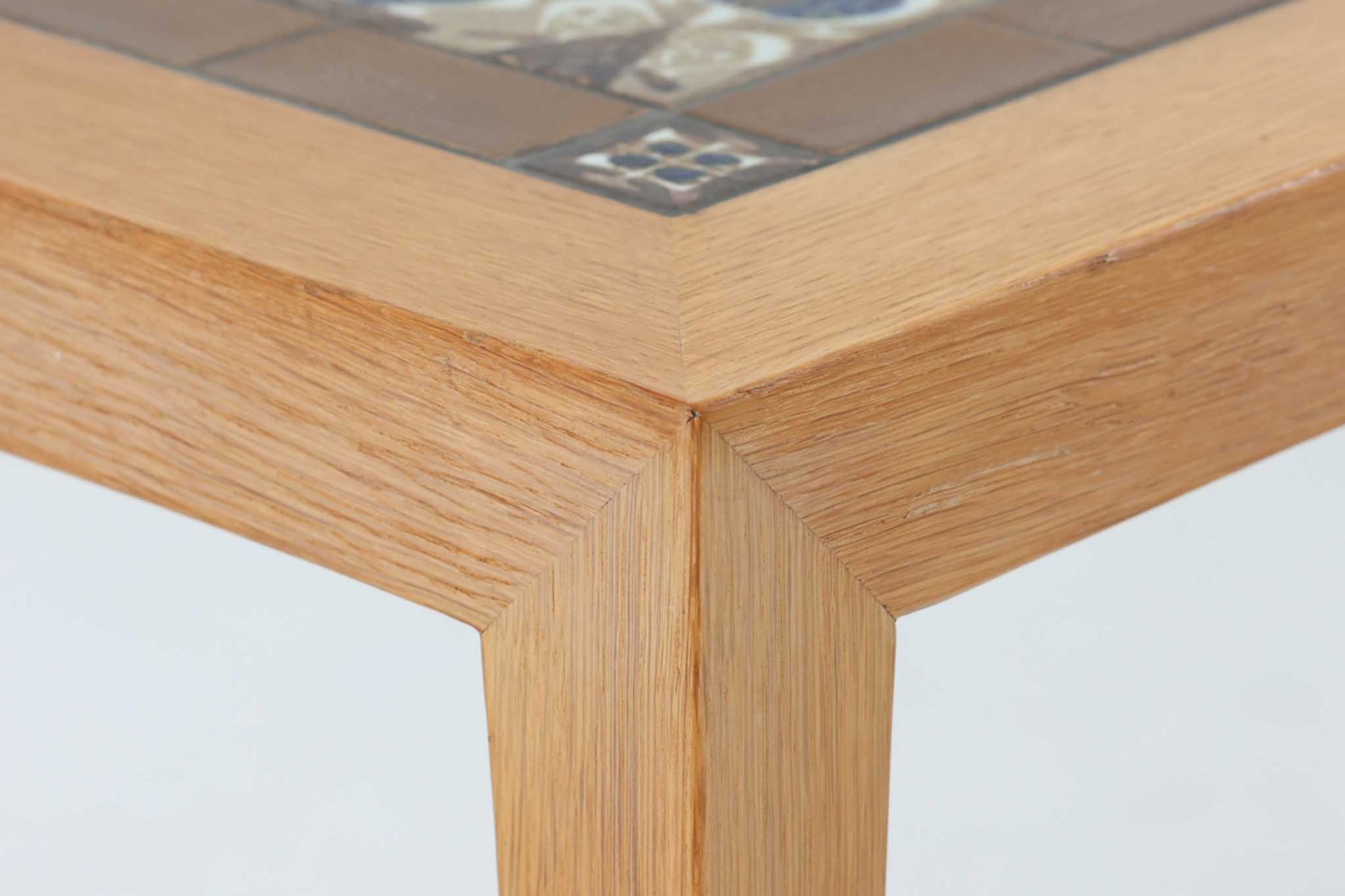 デンマークの家具デザイナー、Severin Hansen Jr.によってデザインされたビンテージのサイドテーブルです。製造はデンマークの名門家具メーカー「Haslev（ハスレヴ）」社。天板にはRoyal Copenhagen（ロイヤルコペンハーゲン）のアートタイルが贅沢にあしらわれています。タイルはNils Thorsson（ニルス・トーソン）が手掛けた人気の「BACA（バッカ）」シリーズ。象徴的なブルーとブラウンの色使いと、有機的かつ幾何学的なモチーフが印象的で、アートピースとしての存在感を放ちます。テーブル本体はオーク材を使用しており、Severin Hansen Jr.の特徴でもあるシャープなカットが施されたコーナーと、すっきりとしたテーパードレッグが、シンプルながら洗練された美しさを醸し出しています。ヴィンテージならではの深い味わいと、アート性・機能性を兼ね備えた一台。リビングやベッドサイドに、さりげなく上質な北欧デザインを取り入れてみてはいかがでしょうか。