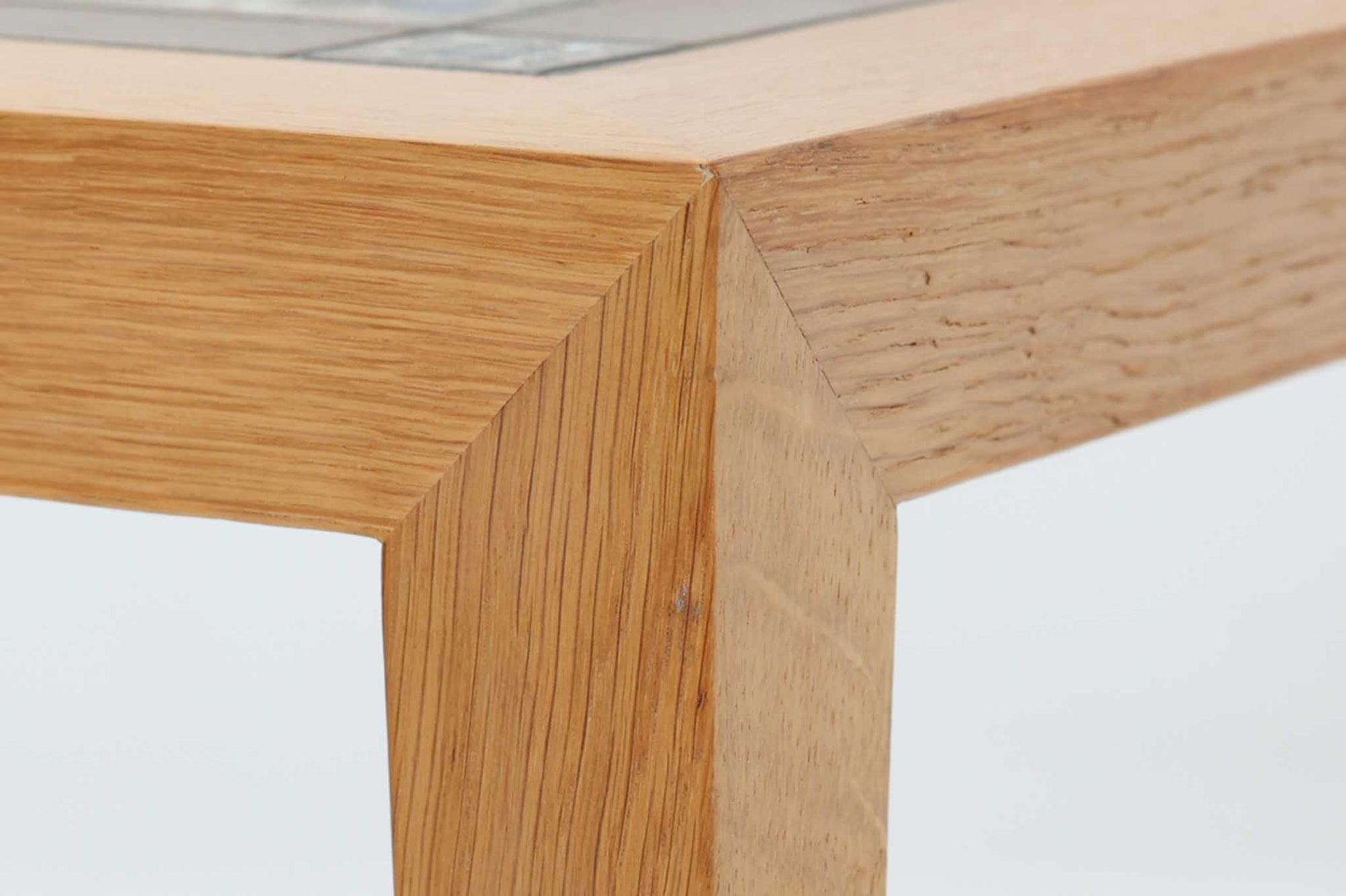 デンマークの家具デザイナー、Severin Hansen Jr.によってデザインされたビンテージのサイドテーブルです。製造はデンマークの名門家具メーカー「Haslev（ハスレヴ）」社。天板にはRoyal Copenhagen（ロイヤルコペンハーゲン）のアートタイルが贅沢にあしらわれています。タイルはNils Thorsson（ニルス・トーソン）が手掛けた人気の「BACA（バッカ）」シリーズ。象徴的なブルーとブラウンの色使いと、有機的かつ幾何学的なモチーフが印象的で、アートピースとしての存在感を放ちます。テーブル本体はオーク材を使用しており、Severin Hansen Jr.の特徴でもあるシャープなカットが施されたコーナーと、すっきりとしたテーパードレッグが、シンプルながら洗練された美しさを醸し出しています。ヴィンテージならではの深い味わいと、アート性・機能性を兼ね備えた一台。リビングやベッドサイドに、さりげなく上質な北欧デザインを取り入れてみてはいかがでしょうか。