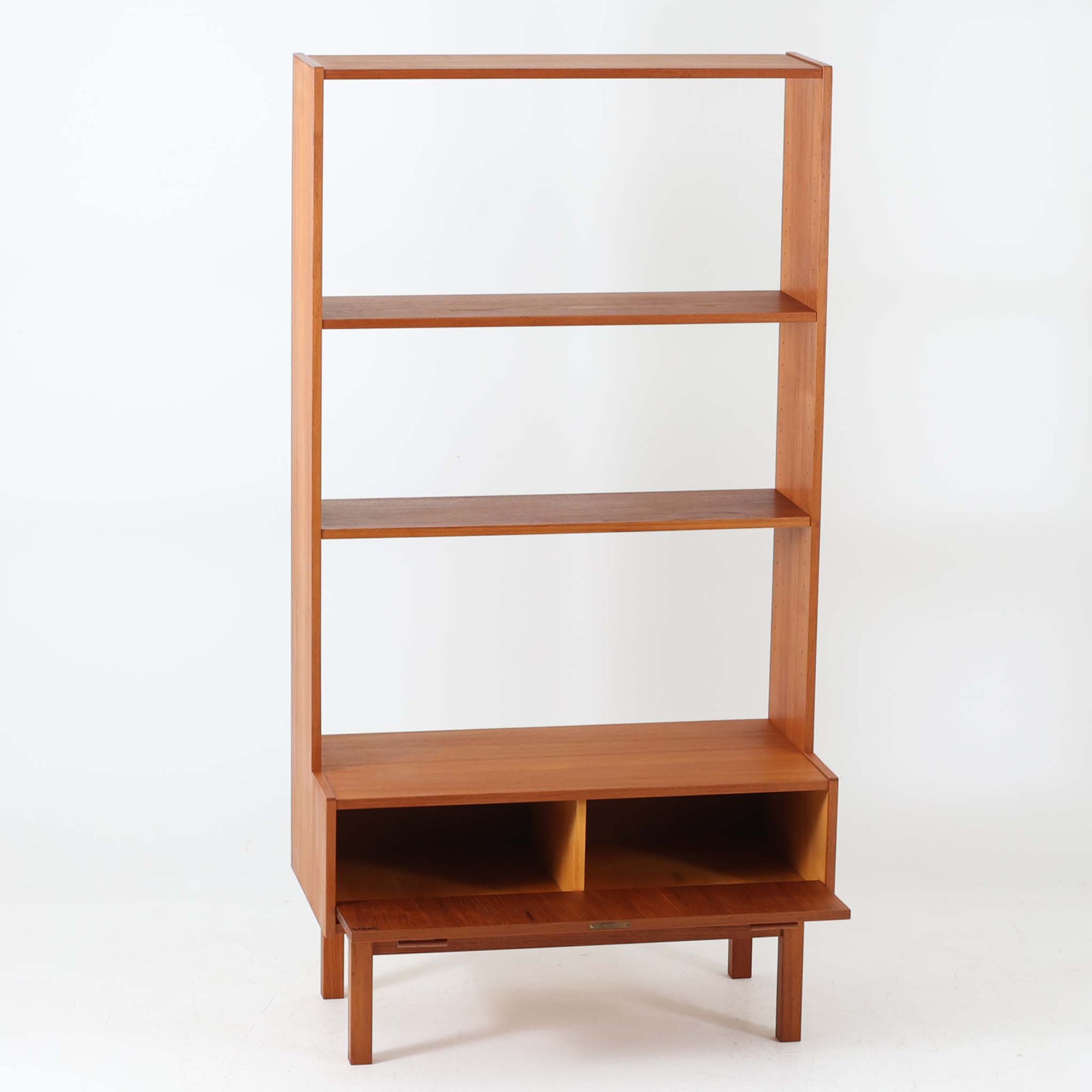 Breox Mobler社によってスウェーデンで製造されたこちらのディスプレイシェルフは、チーク材の温かみある風合いと機能美を兼ね備えた北欧ビンテージ家具です。上段は高さのある3段の棚構成となっており、書籍や小物、アートピースなどを美しく飾るのに適した開放的な設計です。下段には鍵付きのフラップ式収納が備えられ、生活感のあるアイテムをすっきりと隠せる実用的な構造となっています。直線的で軽やかなデザインは圧迫感がなく、省スペースでありながら高い収納力を誇ります。チーク材特有の深みある色合いが魅力で、リビングや書斎、寝室などあらゆる空間に馴染みます。北欧ビンテージ家具ならではの経年変化と上質な存在感をお楽しみいただけます。