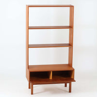 Breox Mobler社によってスウェーデンで製造されたこちらのディスプレイシェルフは、チーク材の温かみある風合いと機能美を兼ね備えた北欧ビンテージ家具です。上段は高さのある3段の棚構成となっており、書籍や小物、アートピースなどを美しく飾るのに適した開放的な設計です。下段には鍵付きのフラップ式収納が備えられ、生活感のあるアイテムをすっきりと隠せる実用的な構造となっています。直線的で軽やかなデザインは圧迫感がなく、省スペースでありながら高い収納力を誇ります。チーク材特有の深みある色合いが魅力で、リビングや書斎、寝室などあらゆる空間に馴染みます。北欧ビンテージ家具ならではの経年変化と上質な存在感をお楽しみいただけます。