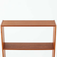 Breox Mobler社によってスウェーデンで製造されたこちらのディスプレイシェルフは、チーク材の温かみある風合いと機能美を兼ね備えた北欧ビンテージ家具です。上段は高さのある3段の棚構成となっており、書籍や小物、アートピースなどを美しく飾るのに適した開放的な設計です。下段には鍵付きのフラップ式収納が備えられ、生活感のあるアイテムをすっきりと隠せる実用的な構造となっています。直線的で軽やかなデザインは圧迫感がなく、省スペースでありながら高い収納力を誇ります。チーク材特有の深みある色合いが魅力で、リビングや書斎、寝室などあらゆる空間に馴染みます。北欧ビンテージ家具ならではの経年変化と上質な存在感をお楽しみいただけます。