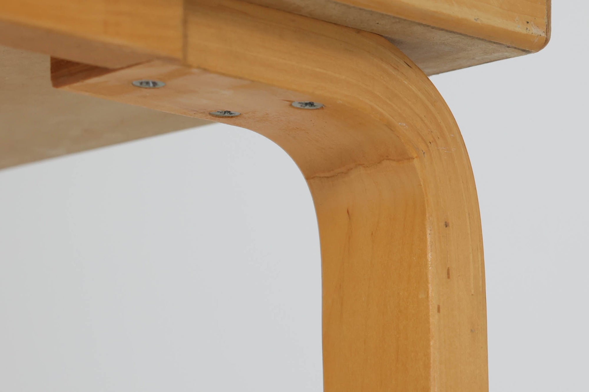 Artek社による、Alvar Aaltoデザインの幅120cmのダイニングテーブル。1970～1980年代に製造されたと考えられるヴィンテージ品です。Aaltoらしい流れるような曲線と、機能美を兼ね備えたデザインが特徴的。天板にはリノリウムが施されており、落ち着いたマットな質感と耐久性を備えています。温かみのあるバーチ材のフレームと、鮮やかなレッドの天板が美しいコントラストを生み出し、空間に独特の存在感を与えます。シンプルでありながら洗練された佇まいは、北欧デザインの魅力を存分に感じさせる一台です。