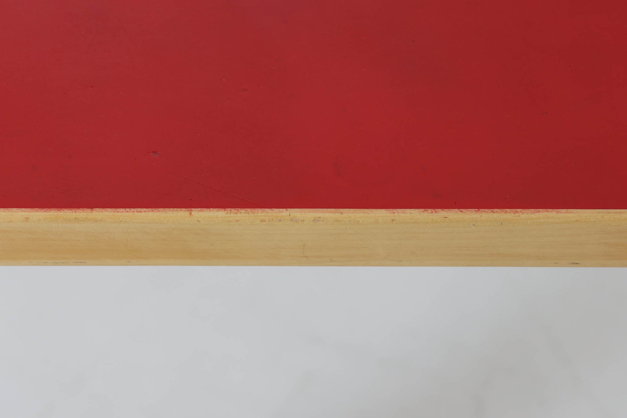 Artek社による、Alvar Aaltoデザインの幅120cmのダイニングテーブル。1970～1980年代に製造されたと考えられるヴィンテージ品です。Aaltoらしい流れるような曲線と、機能美を兼ね備えたデザインが特徴的。天板にはリノリウムが施されており、落ち着いたマットな質感と耐久性を備えています。温かみのあるバーチ材のフレームと、鮮やかなレッドの天板が美しいコントラストを生み出し、空間に独特の存在感を与えます。シンプルでありながら洗練された佇まいは、北欧デザインの魅力を存分に感じさせる一台です。