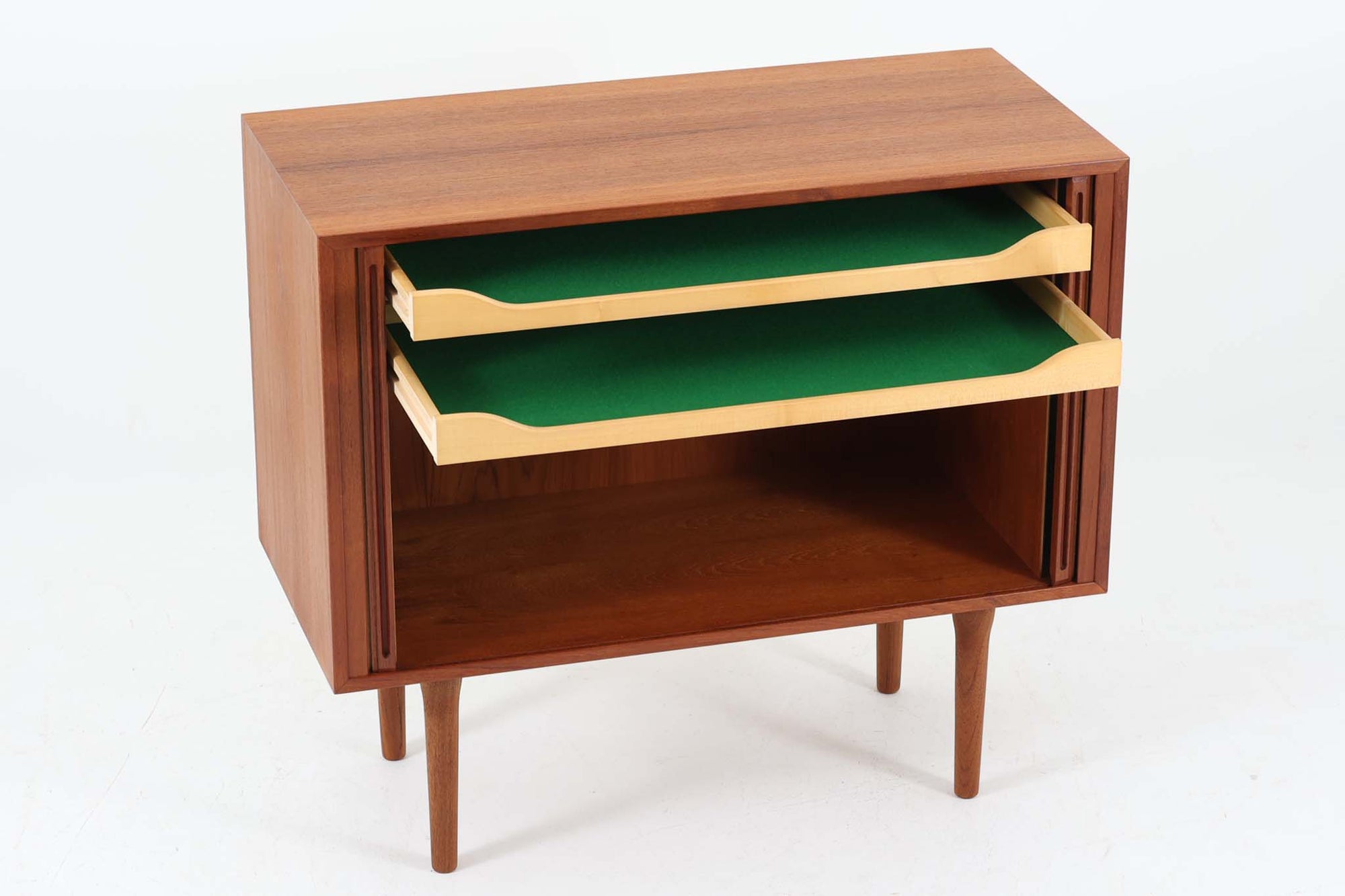 デンマークのデザイナー、Kai Kristiansen（カイ・クリスチャンセン）によってデザインされた、Fm furniture社製のビンテージキャビネットです。素材には上質なチーク材が用いられており、深みのある美しい木目とあたたかみのある色合いが魅力です。フロントには、機能性とデザイン性を兼ね備えた蛇腹扉が採用されており、開閉の動作そのものが楽しめる一台です。内部にはフェルトが敷かれた引き出し2段と収納スペースがあり、カトラリーや書類、小物の整理にも最適です。高さのある丸脚は、北欧家具らしい軽やかな印象を与えながらも、根元にかけてややふくらみを持たせた独特のフォルムとなっており、全体のデザイン性を高めています。コンパクトなサイズ感は空間を圧迫せず、リビングや玄関、書斎など様々なシーンに馴染みます。北欧デザインの美しさと実用性を兼ね備えたキャビネットです。