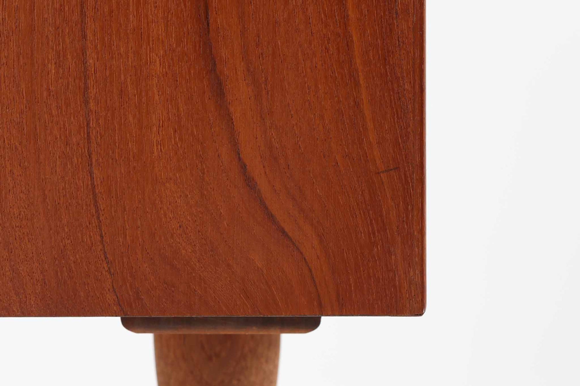 デンマークのデザイナー、Kai Kristiansen（カイ・クリスチャンセン）によってデザインされた、Fm furniture社製のビンテージキャビネットです。素材には上質なチーク材が用いられており、深みのある美しい木目とあたたかみのある色合いが魅力です。フロントには、機能性とデザイン性を兼ね備えた蛇腹扉が採用されており、開閉の動作そのものが楽しめる一台です。内部にはフェルトが敷かれた引き出し2段と収納スペースがあり、カトラリーや書類、小物の整理にも最適です。高さのある丸脚は、北欧家具らしい軽やかな印象を与えながらも、根元にかけてややふくらみを持たせた独特のフォルムとなっており、全体のデザイン性を高めています。コンパクトなサイズ感は空間を圧迫せず、リビングや玄関、書斎など様々なシーンに馴染みます。北欧デザインの美しさと実用性を兼ね備えたキャビネットです。