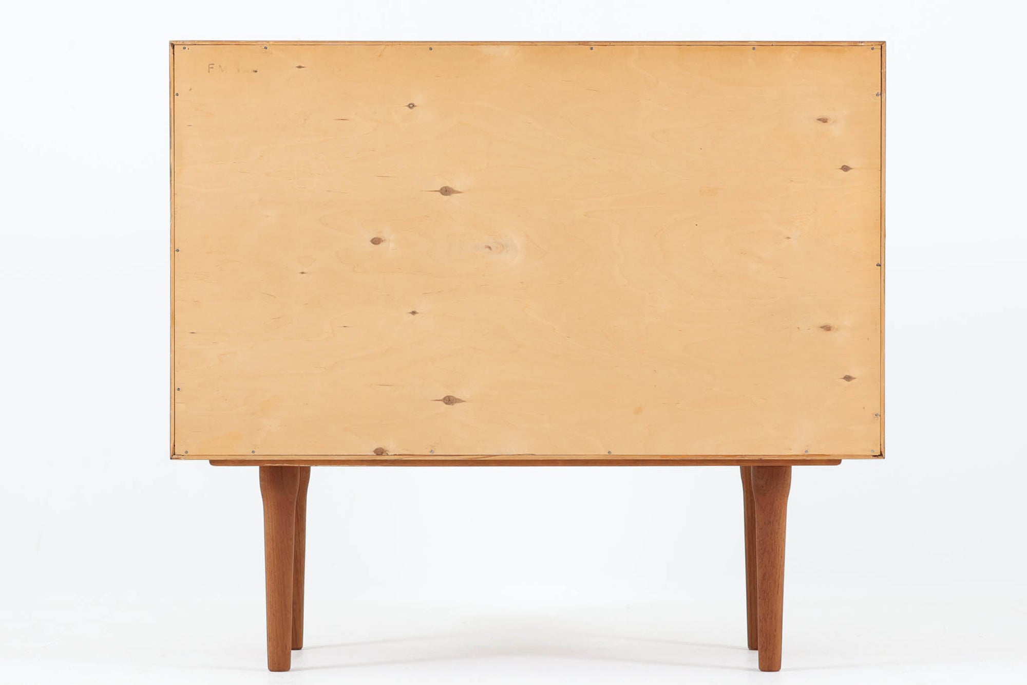 デンマークのデザイナー、Kai Kristiansen（カイ・クリスチャンセン）によってデザインされた、Fm furniture社製のビンテージキャビネットです。素材には上質なチーク材が用いられており、深みのある美しい木目とあたたかみのある色合いが魅力です。フロントには、機能性とデザイン性を兼ね備えた蛇腹扉が採用されており、開閉の動作そのものが楽しめる一台です。内部にはフェルトが敷かれた引き出し2段と収納スペースがあり、カトラリーや書類、小物の整理にも最適です。高さのある丸脚は、北欧家具らしい軽やかな印象を与えながらも、根元にかけてややふくらみを持たせた独特のフォルムとなっており、全体のデザイン性を高めています。コンパクトなサイズ感は空間を圧迫せず、リビングや玄関、書斎など様々なシーンに馴染みます。北欧デザインの美しさと実用性を兼ね備えたキャビネットです。