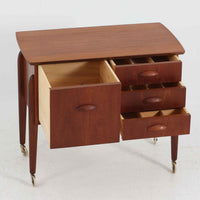 チーク材を使用したデンマーク製のソーイングテーブルです。丸みを帯びた脚部と有機的な取っ手のデザインが愛らしく、温かみのある木目が上品な印象を与えます。引き出し内には仕切りが設けられ、小物の整理にも便利。キャスター付きで移動もスムーズに行えます。ミシン台や裁縫用としてはもちろん、リビングでサイドテーブルや収納台としても活躍する汎用性の高い一台です。経年によるチークの深い色艶が、北欧ビンテージ家具ならではの趣を添えています。