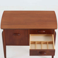 チーク材を使用したデンマーク製のソーイングテーブルです。丸みを帯びた脚部と有機的な取っ手のデザインが愛らしく、温かみのある木目が上品な印象を与えます。引き出し内には仕切りが設けられ、小物の整理にも便利。キャスター付きで移動もスムーズに行えます。ミシン台や裁縫用としてはもちろん、リビングでサイドテーブルや収納台としても活躍する汎用性の高い一台です。経年によるチークの深い色艶が、北欧ビンテージ家具ならではの趣を添えています。