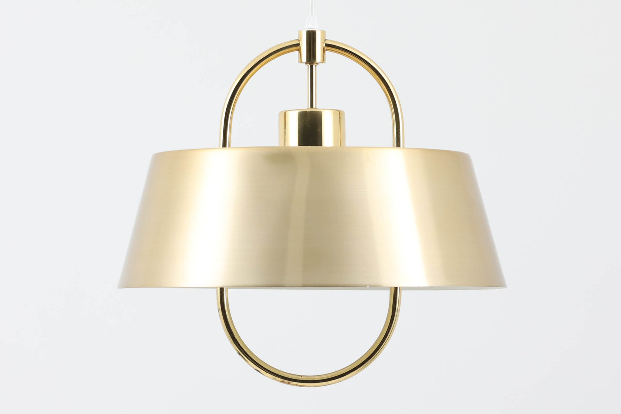 デンマークの照明ブランド、Fog & morup（フォグ＆モーラップ）社によるペンダントライト「Hercules」。デザインは同社を代表するデザイナー、Jo Hammerborg（ヨー・ハーマボー）。直径41cmの存在感あるサイズに、上下を弧状に囲む真鍮製のアームが印象的な構造で、点灯時には下部のリングが光を受けて柔らかく浮かび上がります。外側はゴールドブラス、内側はホワイトで塗装されており、光の反射を美しく拡散させる仕様です。経年により一部にくすみや細かなキズが見られますが、全体としては美しい輝きを保っており、ビンテージならではの雰囲気を楽しめる一点です。E26口金のLED電球に対応し、現代の生活空間でも安心してご使用いただけます。北欧ミッドセンチュリーデザインの象徴的な一灯として、リビングやダイニングのアクセントにおすすめです。